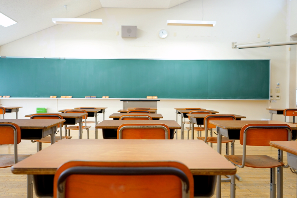 An empty classroom with a chalkboard in the front.