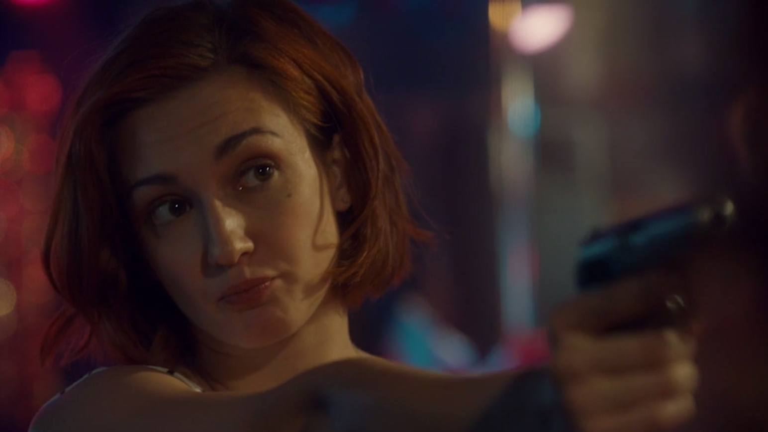Drunk Nicole aims her gun and is making an almost smirk