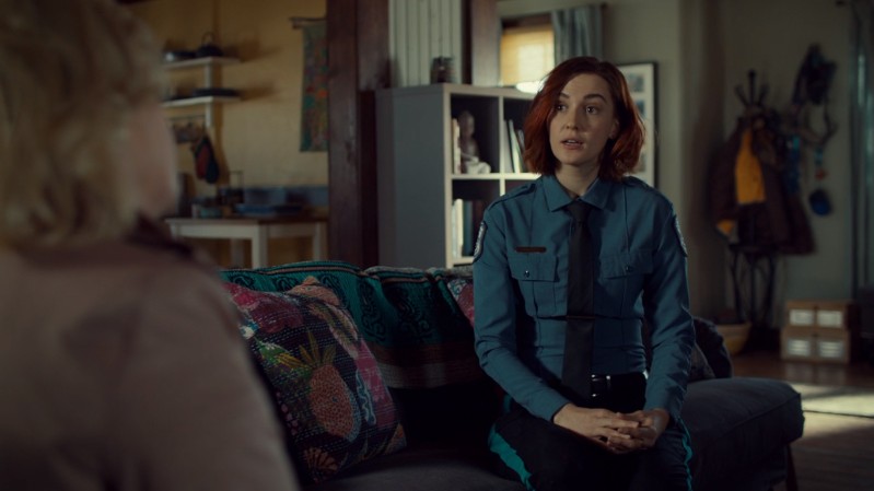 Nicole sits nervously on the couch in A TIE