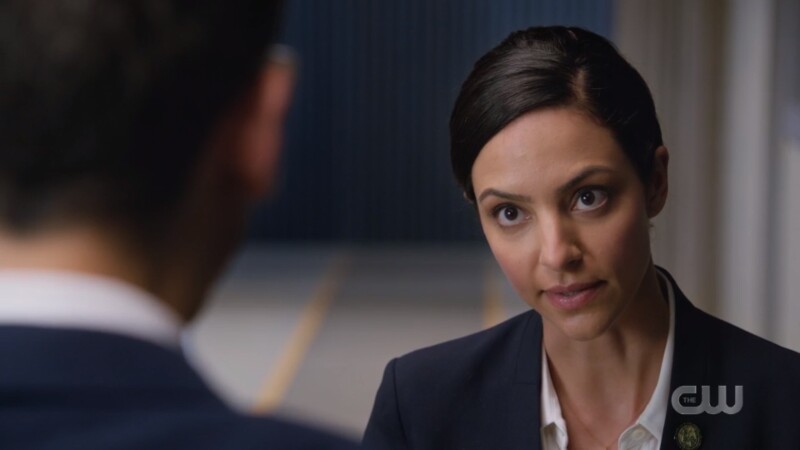 Zari looks sternly at Gary and is dressed like a Time Agent in a blue blazer and a tight bun