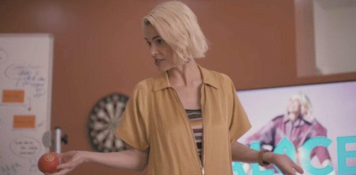 Alice standing in a production meeting, talking to her team about 