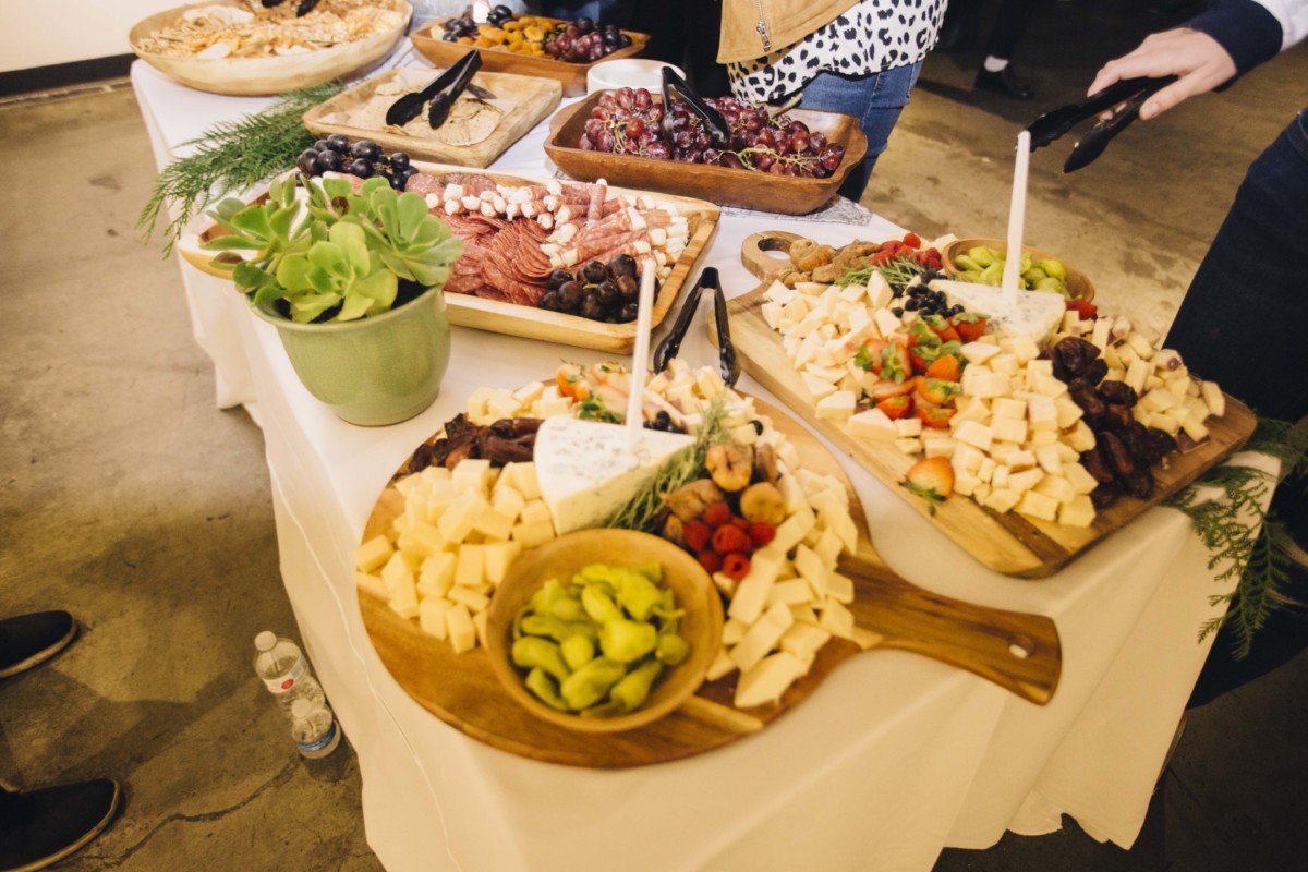 A photo of the food table, featuring multiple different meat and cheese plates.