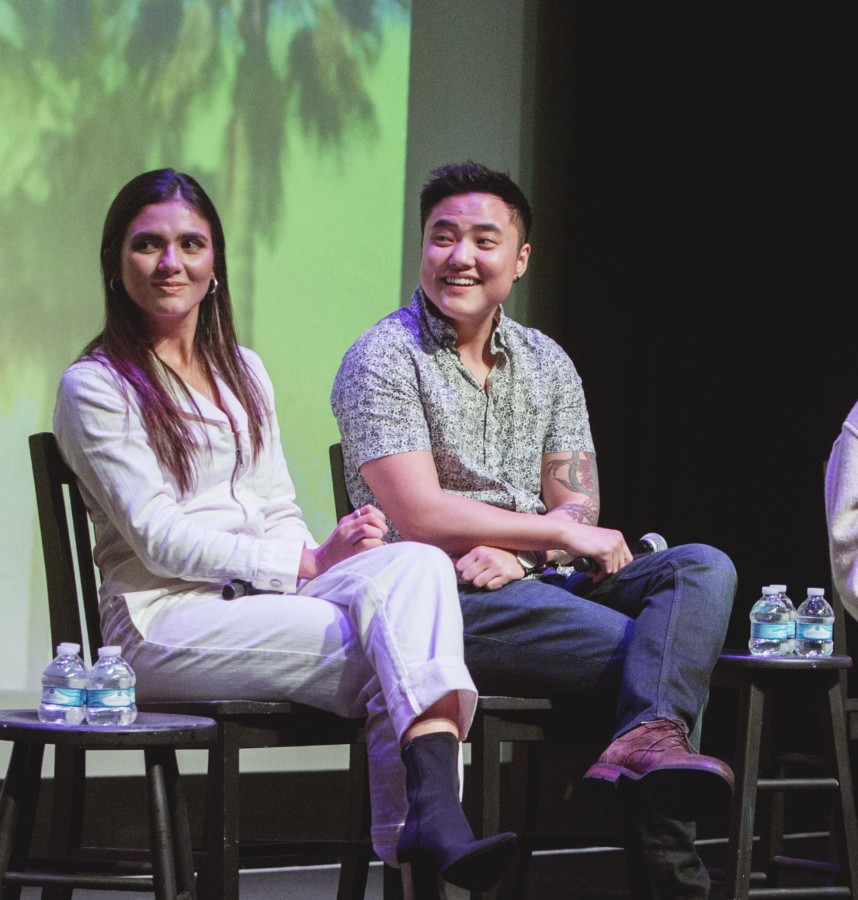 Arienne Mandi and Leo Sheng sit next to each other on stage. They are both smiling and looking to their right.