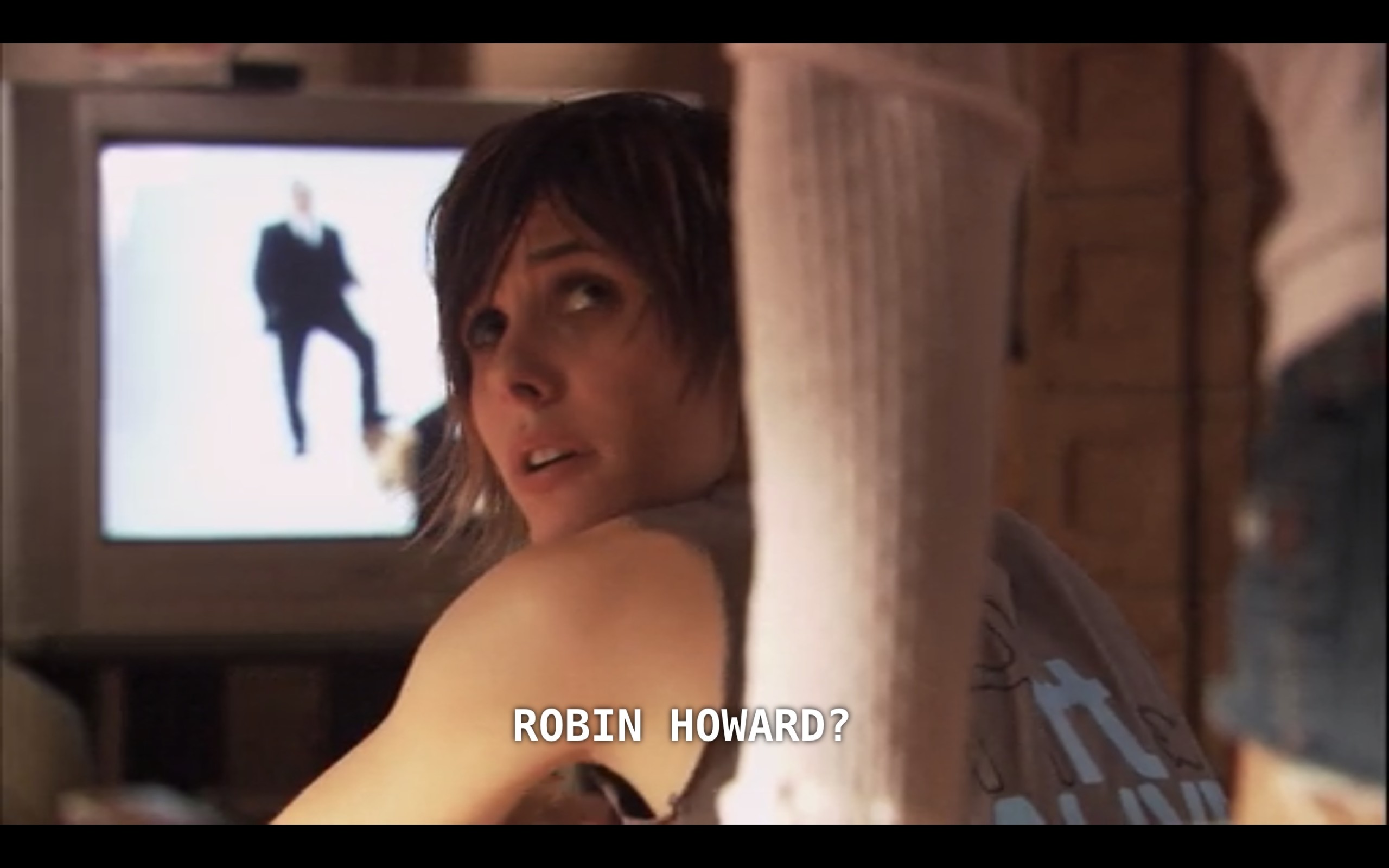 Shane (wearing a blue tank top) looks back over her shoulder at Carmen (whose back is to the camera). Shane asks, "Robin Howard?"