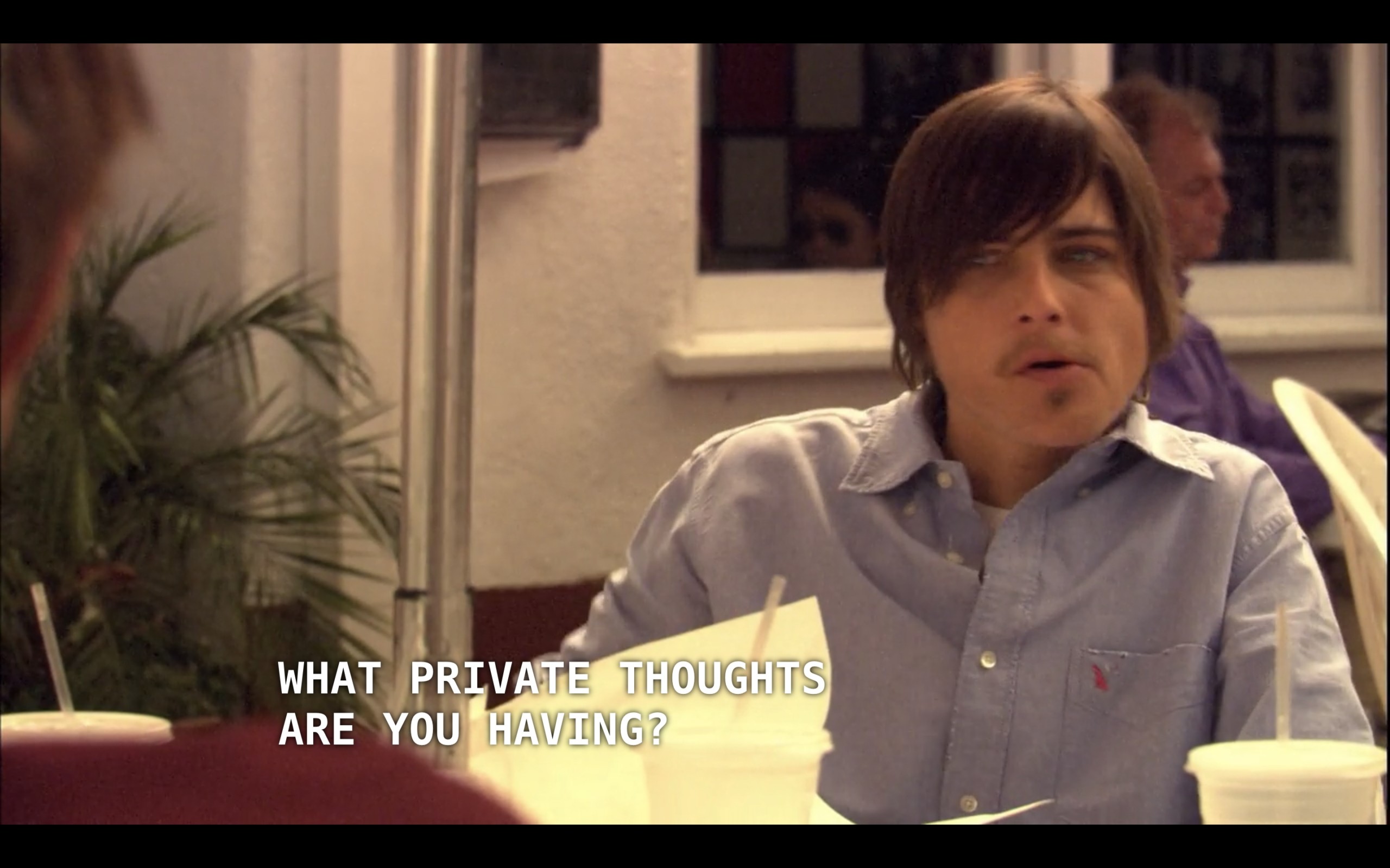 Max (wearing a blue button-up) is sitting at an outdoor table with Jenny, Tim, and his wife (who are all off screen). Tim asks Jenny, "What private thoughts are you having?"