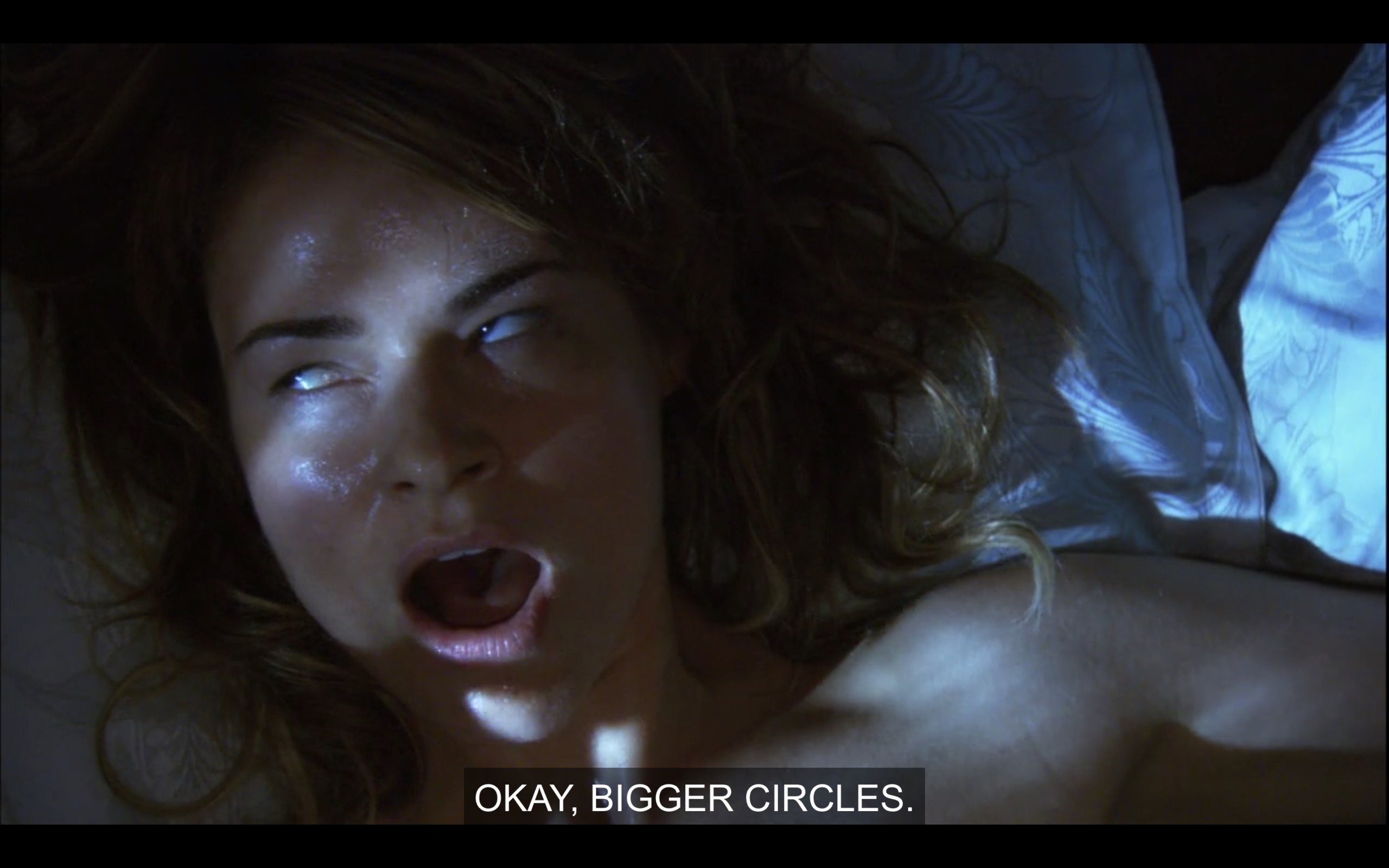 Close up of Alice's sweaty face as she lays in bed while Phyllis goes down on her. Her eyes are slightly rolled back as she says, "Okay, bigger circles."