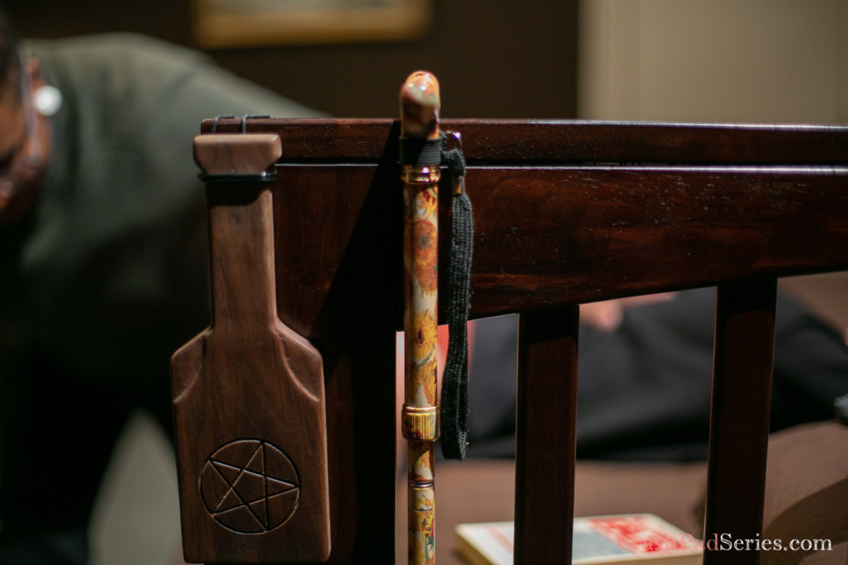 paddles and a crop hanging on the corner of a bed