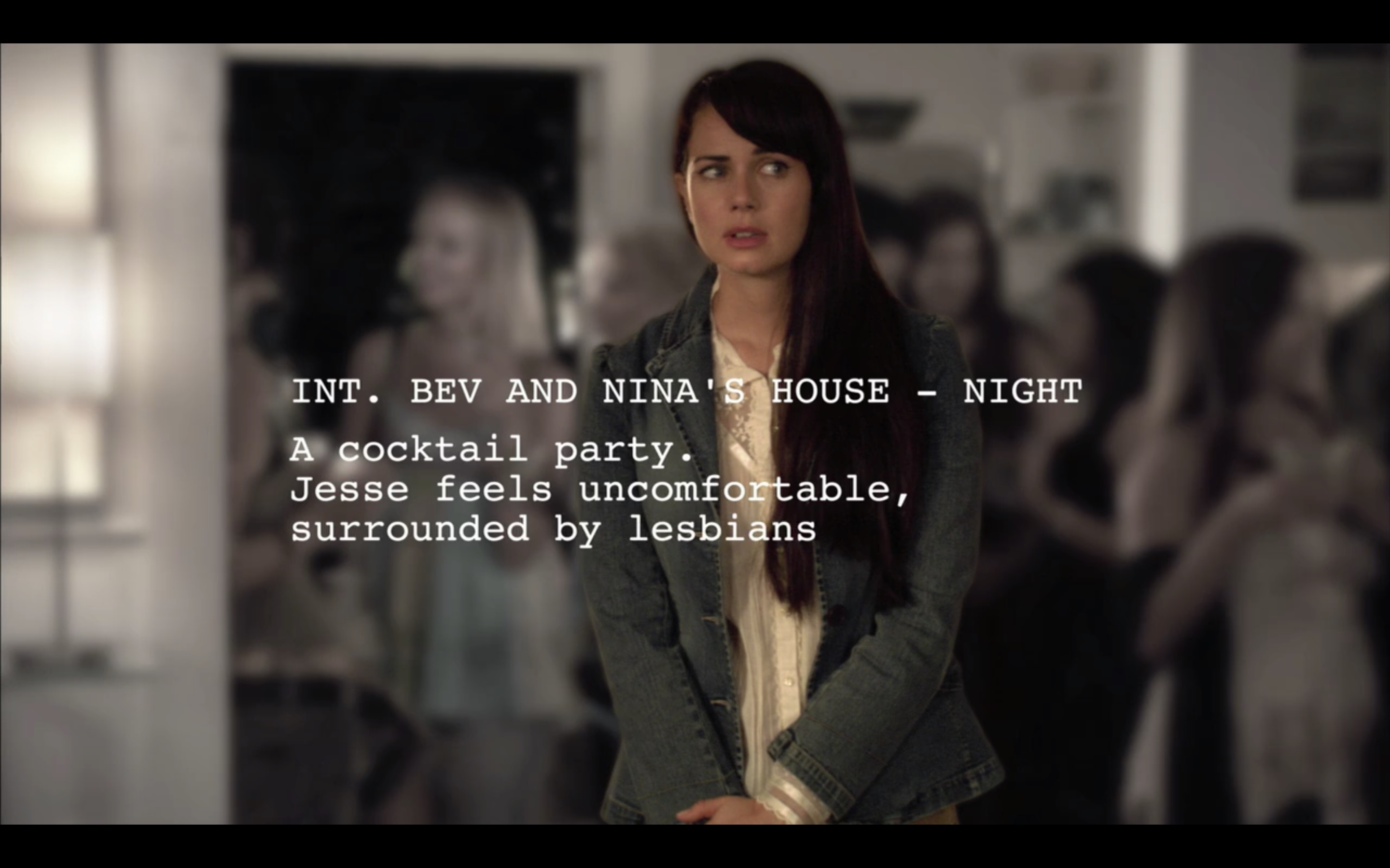 Jenny's screenplay superimposed onto the film in her imagination. She is standing uncertainly in a party in a big jacket. The script says she's at a cocktail party, surrounded by lesbians.