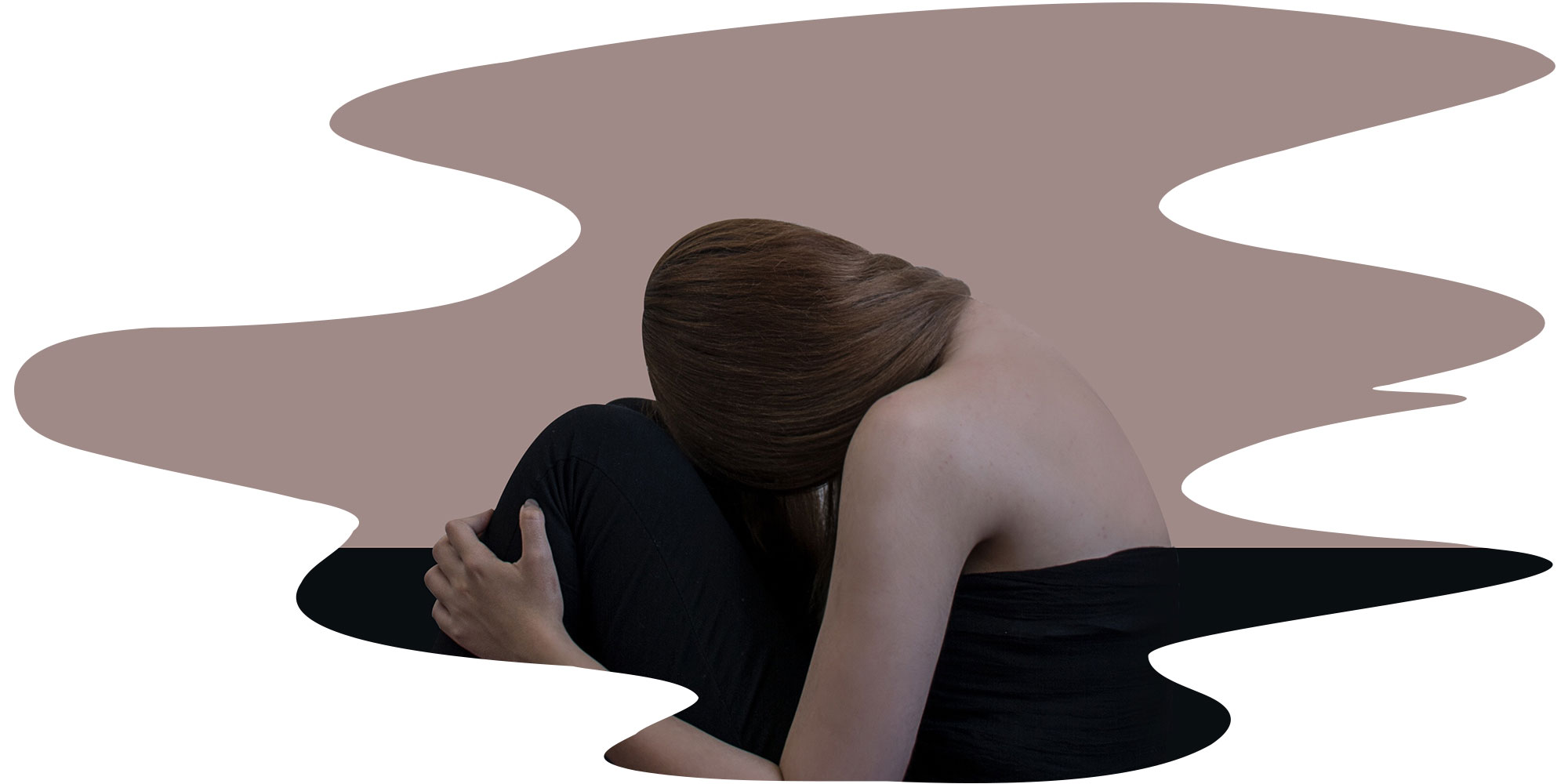 girl curled up with her head on her knees