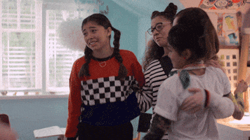 The members of the Baby-Sitters Club join together for a group hug