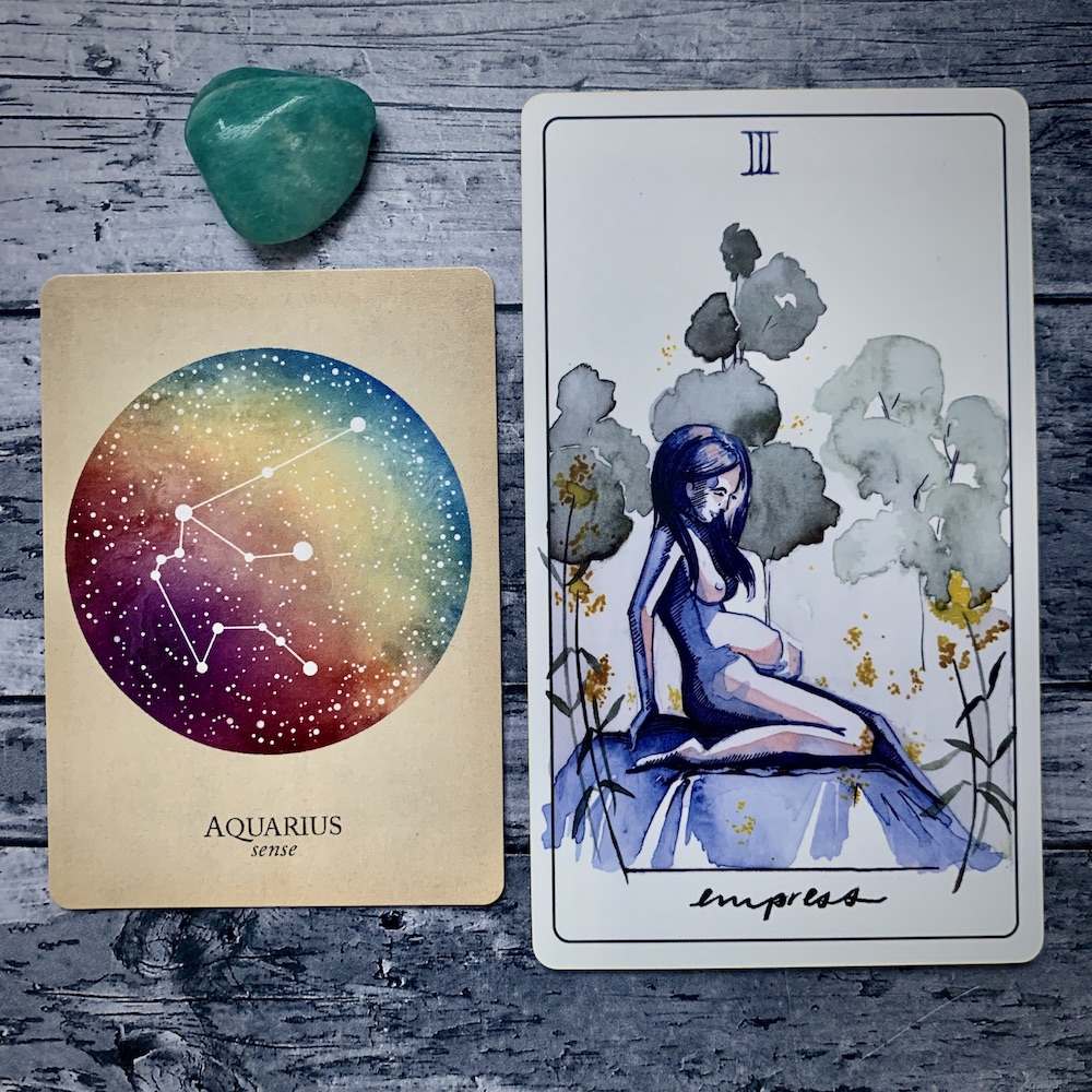 the Aquarius card from the Constellations deck and the Strength card