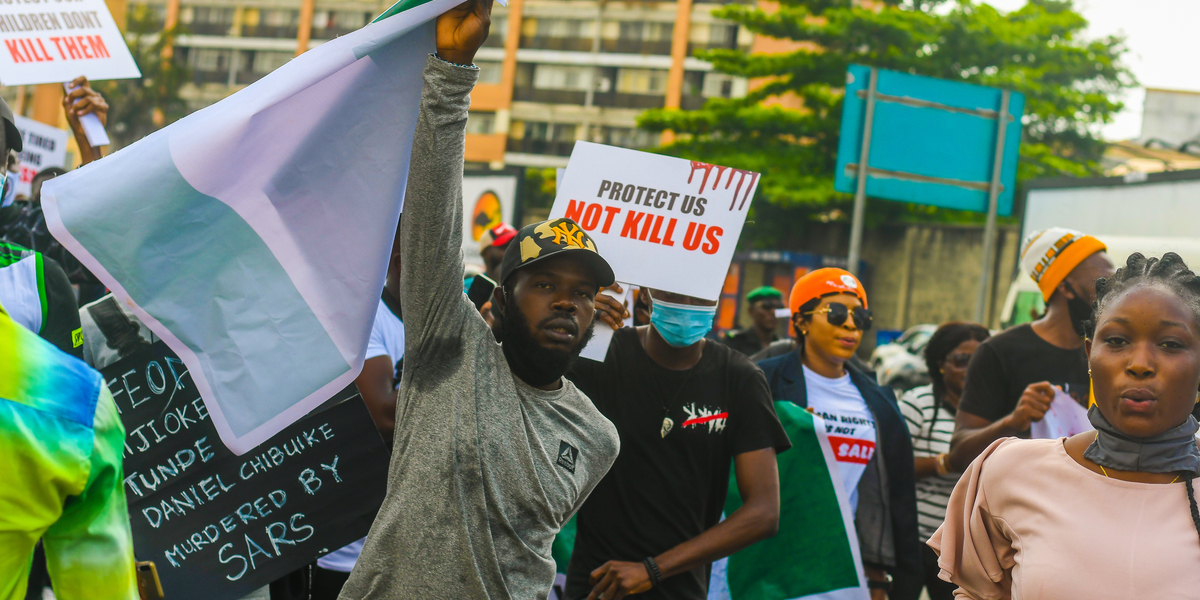 A photo of protesters in Nigeria with signs that read 