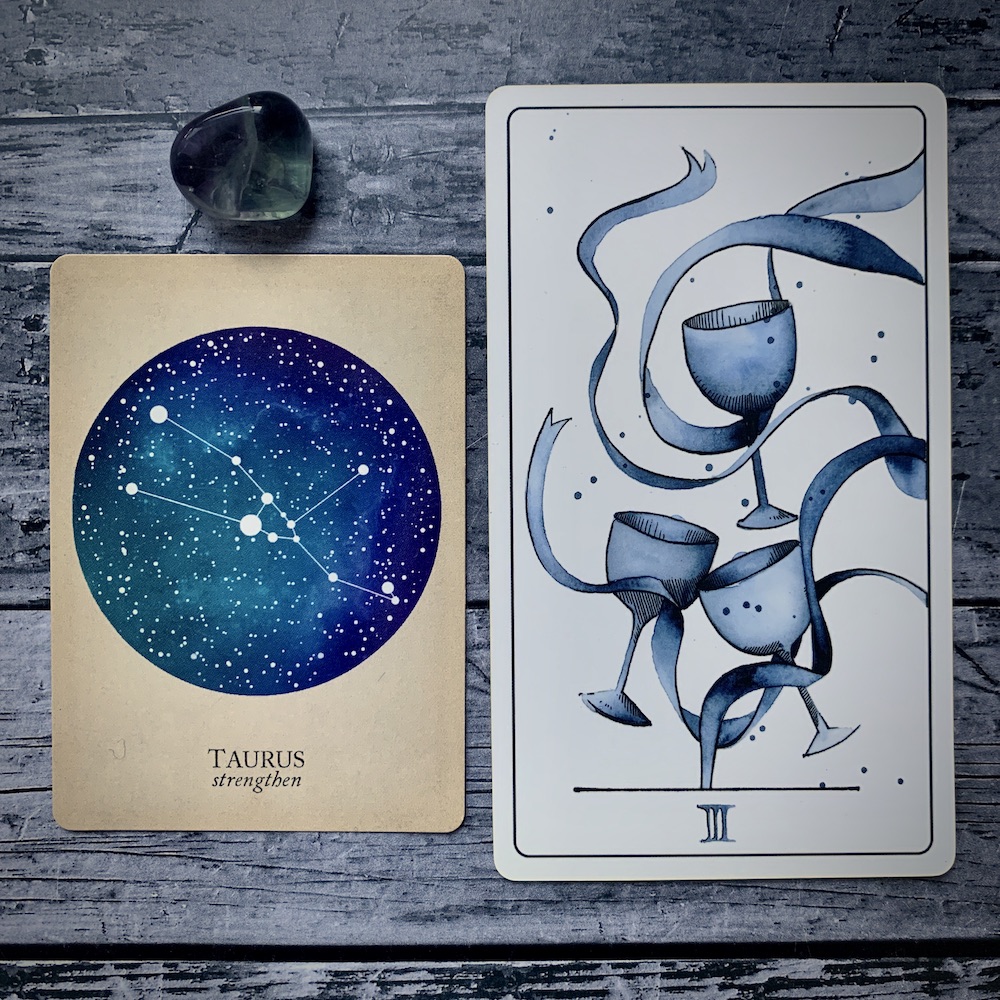 A Taurus card from the Constellations deck and a 3 of Cups card