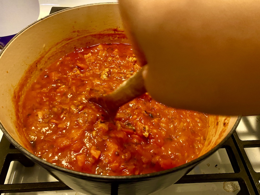 a look into the top of a pot that's filled with a simmering meat sauce