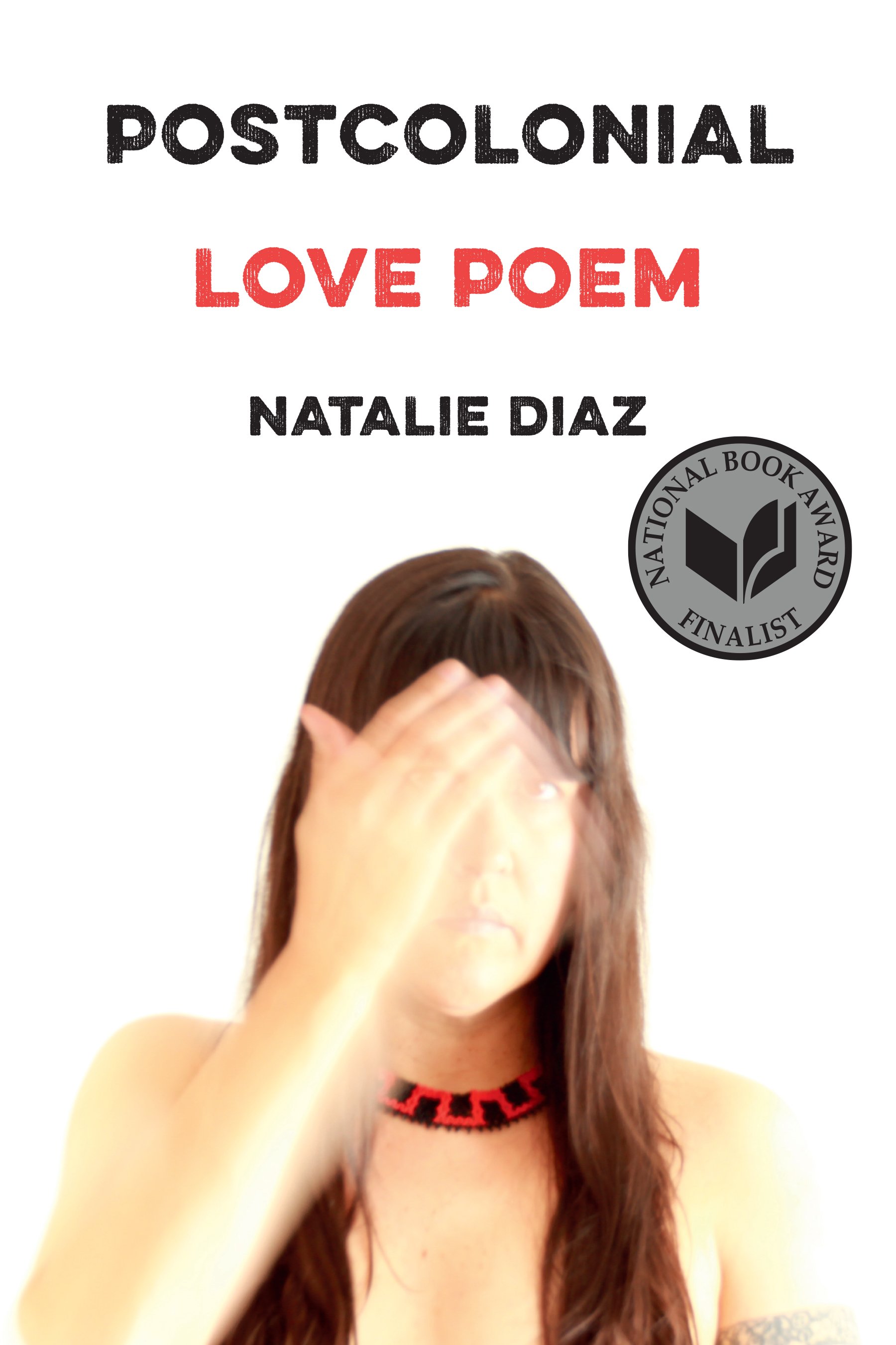 a book cover with a white background and in black text at the top "Postcolonial" in red "Love Poem" and in black again "Natalie Diaz" followed by a photo of Diaz with long hair and a beaded necklack, and a blurred hand passing in front of her face.