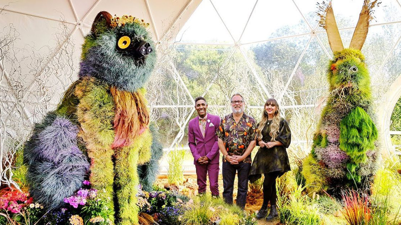 The queer contestants of Fairytale Finale pose in front of their winning flower sculptures.