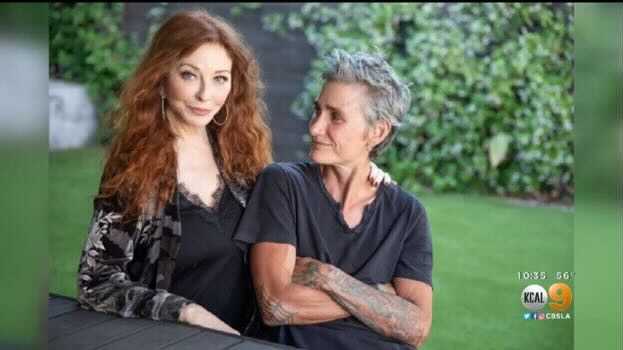 Elvira sits with her girlfriend, puts her hand on her shoulder