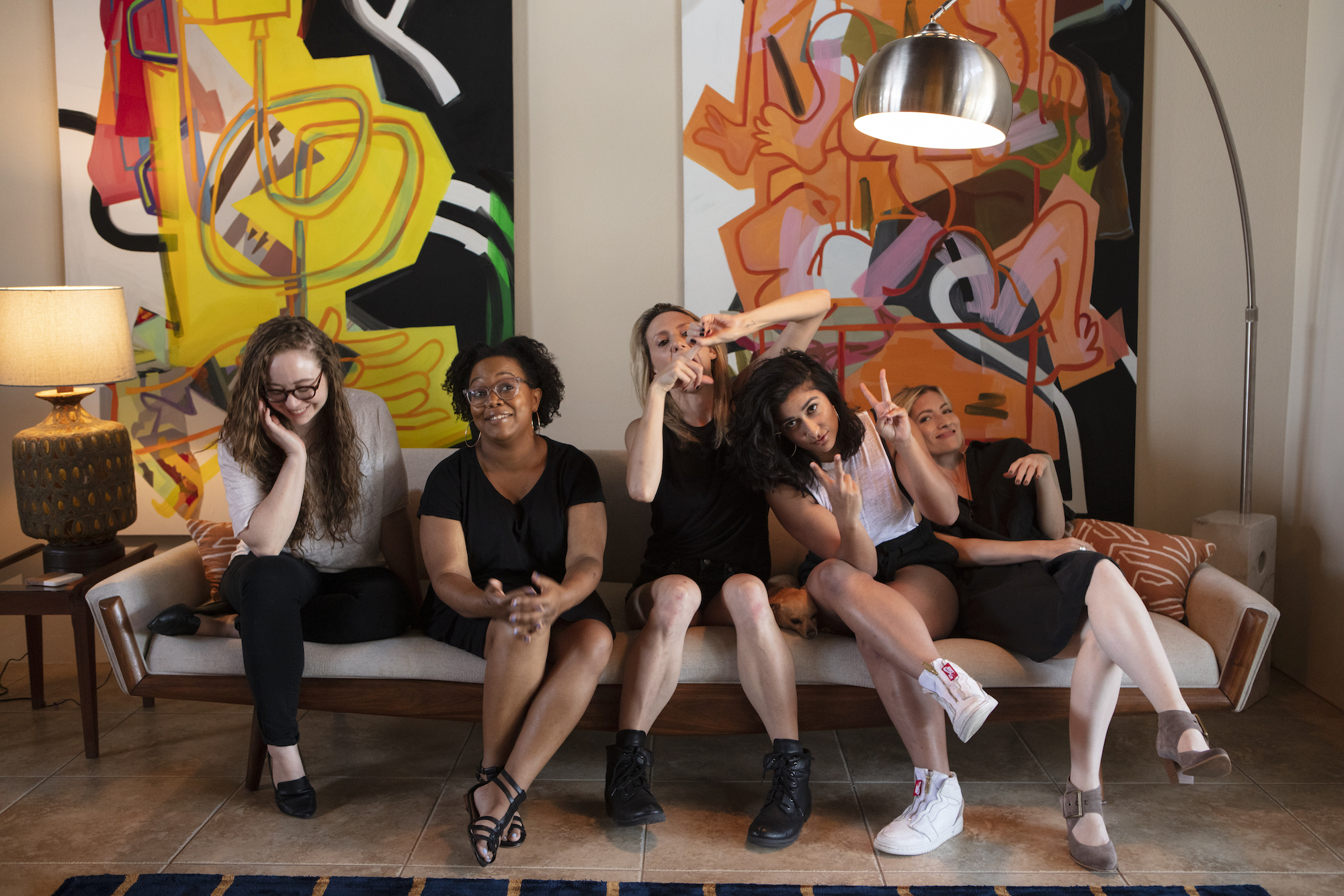 A photo of the Autostraddle Senior Team making funny faces while sitting on the couch: Rachel, Carmen, Riese, Sarah, and Laneia