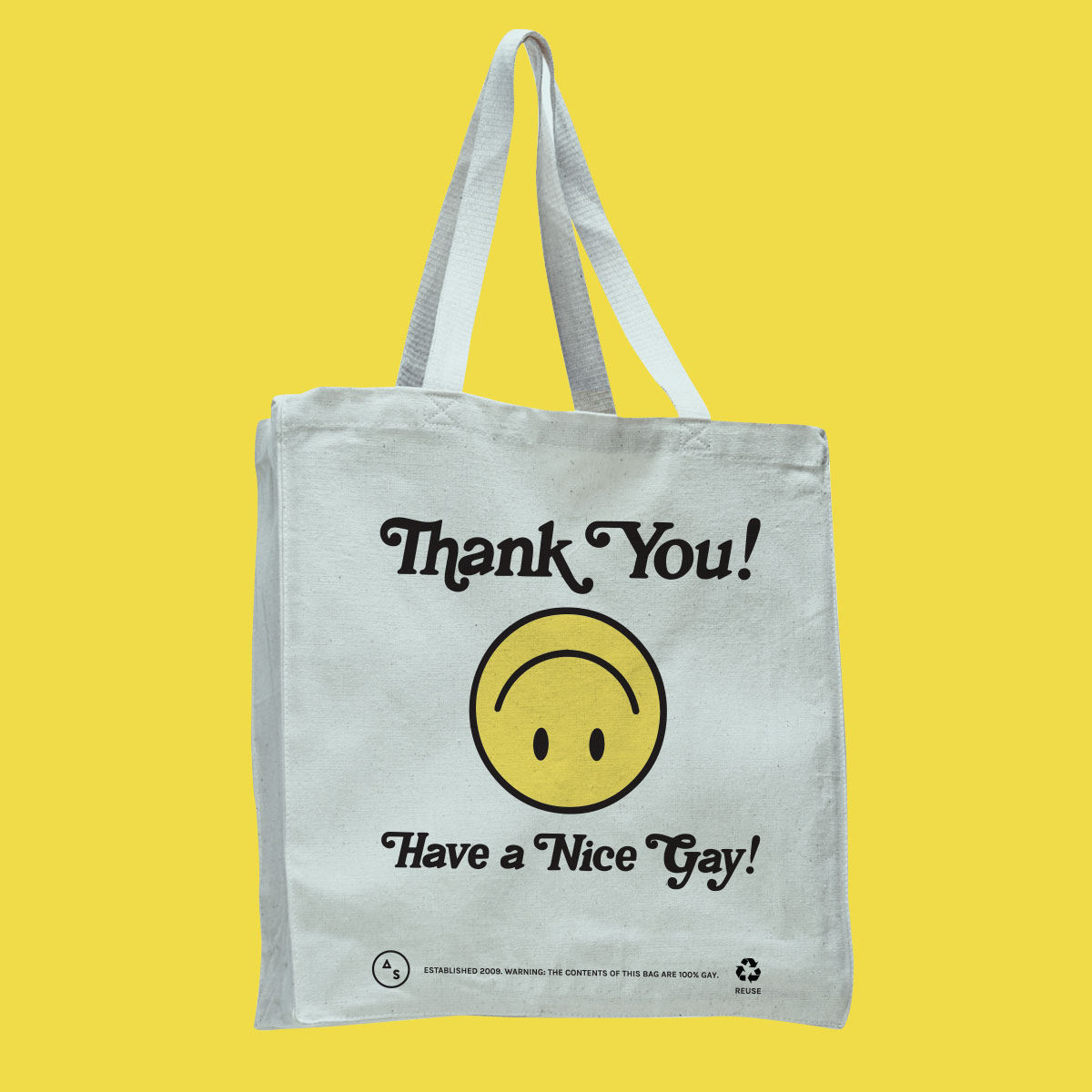 a white tote bag with an upside down yellow smiley face. The bag reads "Thank You Have a Nice Gay!"