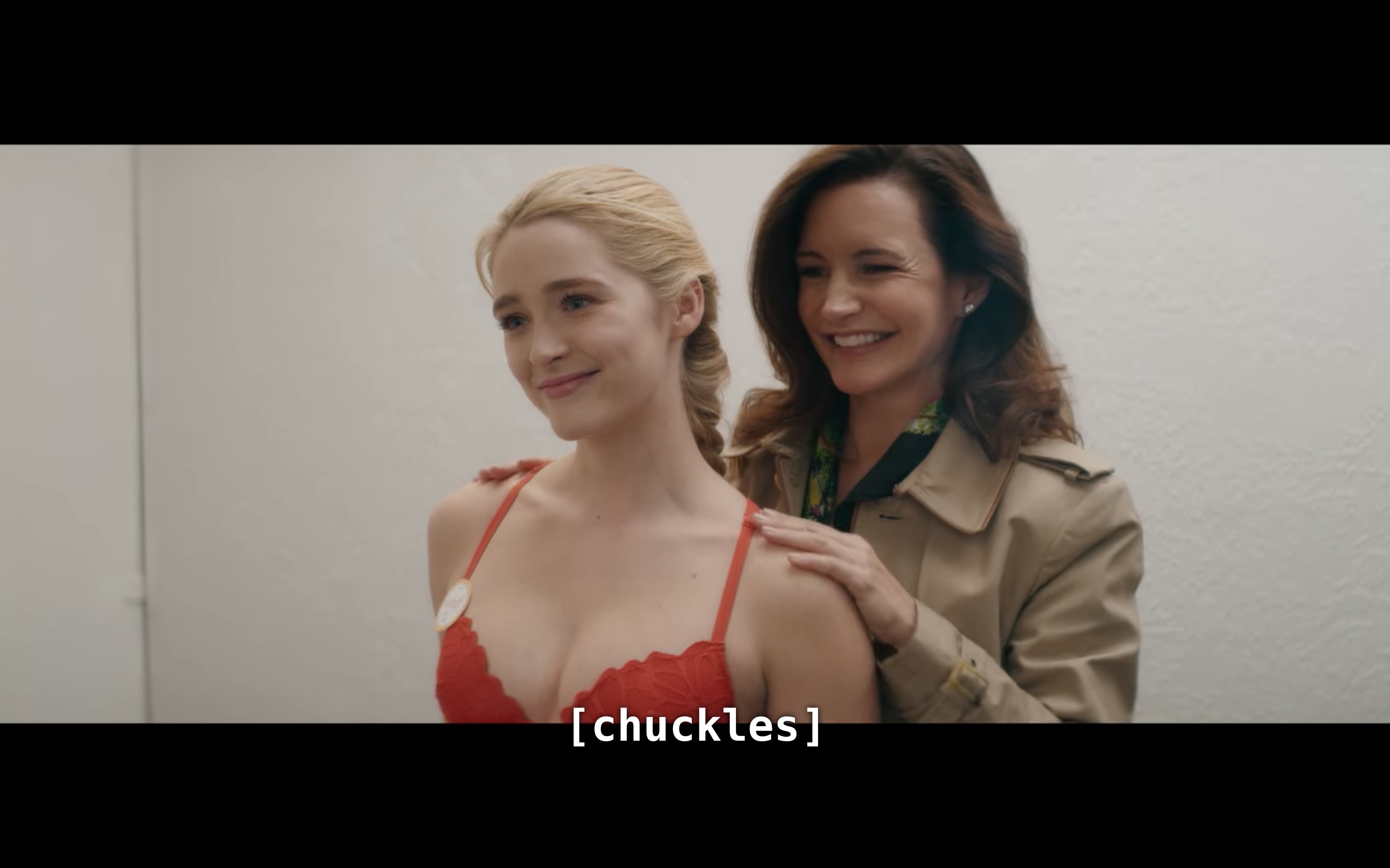 Mary and Grace looking in the mirror of the dressing room, "chuckling"