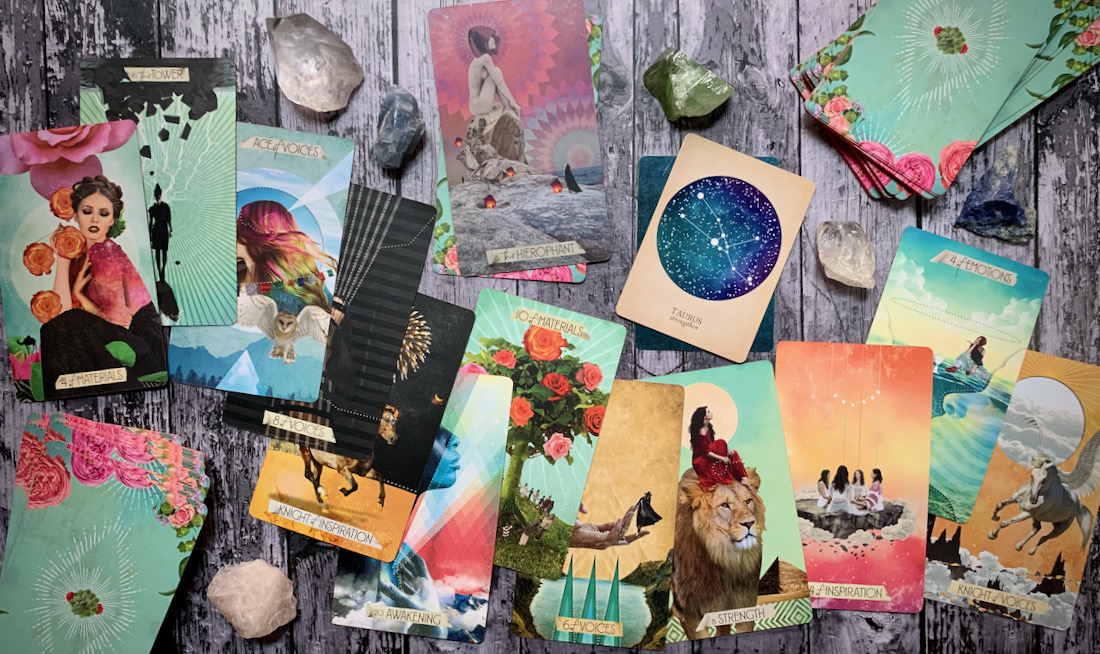 Dozens of colorful tarot cards scattered all over a wooden surface