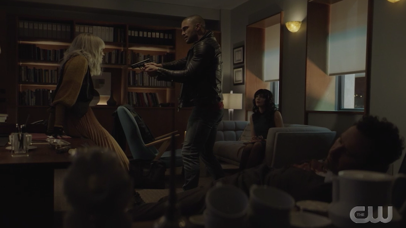 ocean points a gun at alice while enigma sits on the couch and jackson is still dead in his seat