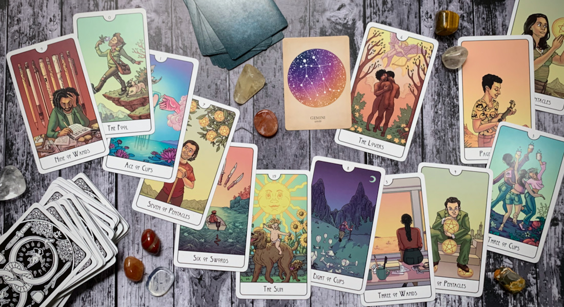 A photo of a set of tarot cards splayed across a light wooden background