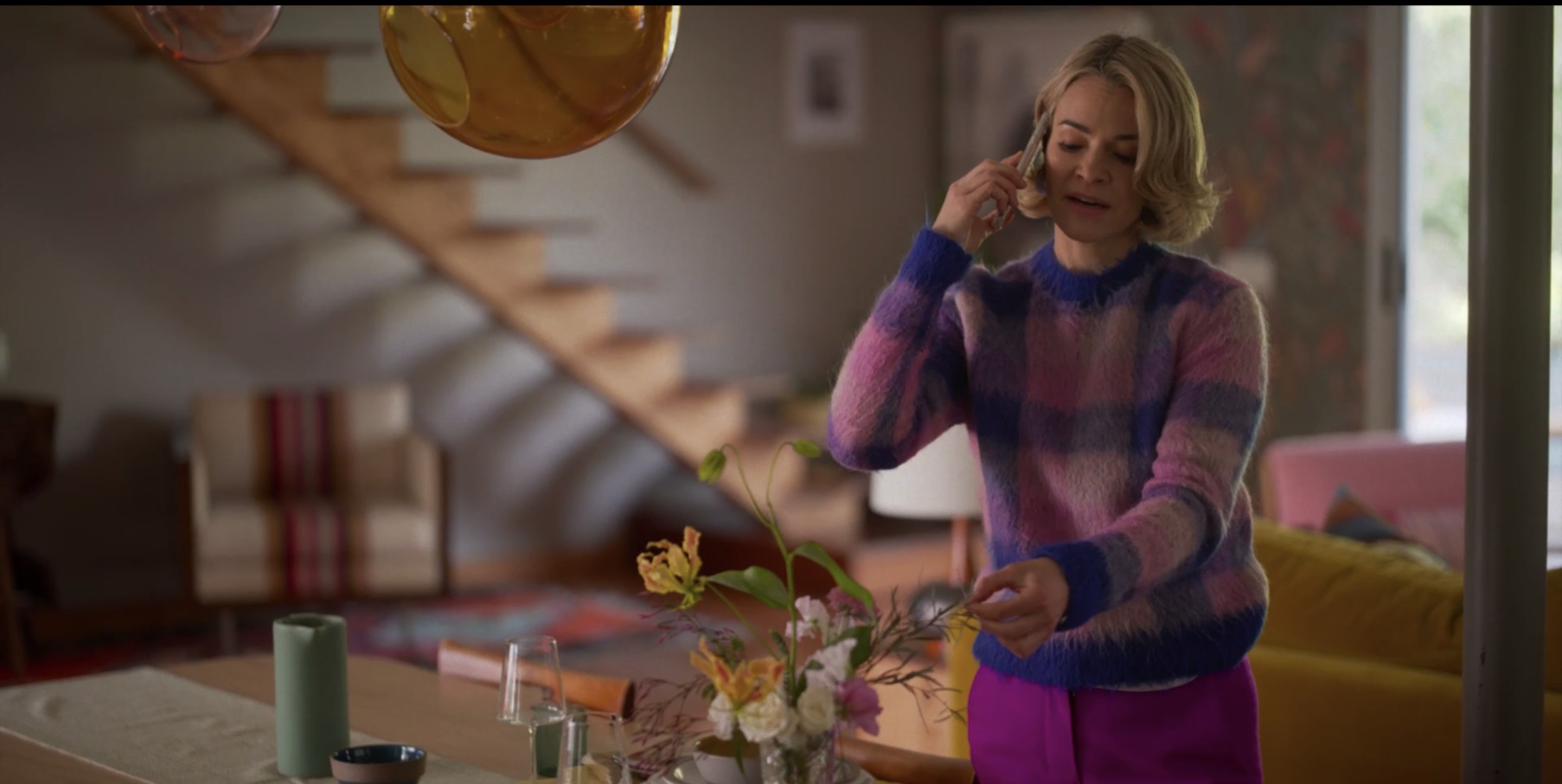 Alice at home touching the flowers in her vase