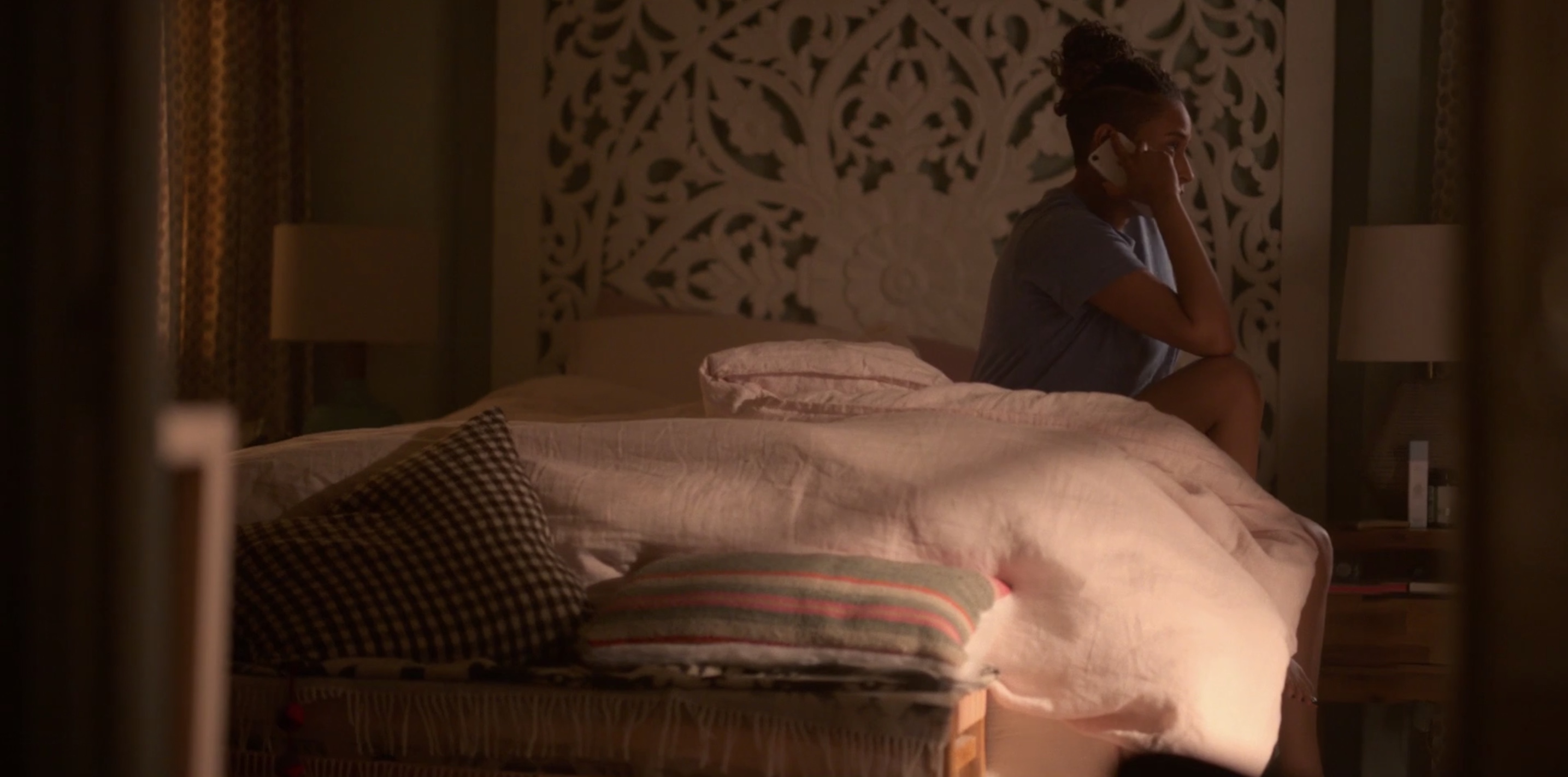 Sophie sitting on her bed with her phone