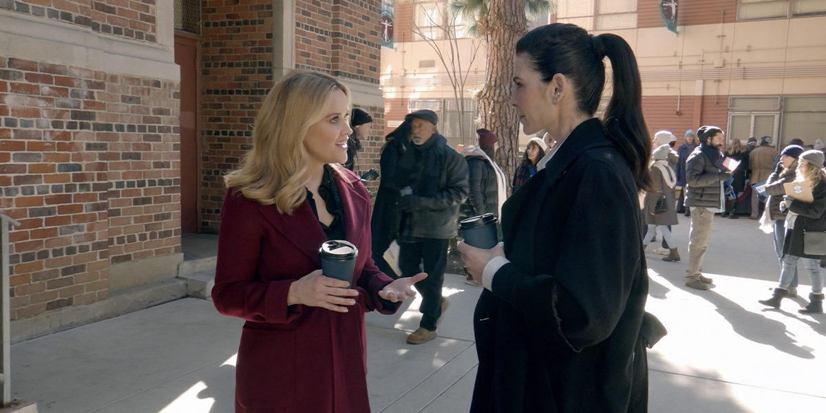 Reese Witherspoon and Juliana Margulies in The Morning Show, holding coffee cups and wearing great jackets.