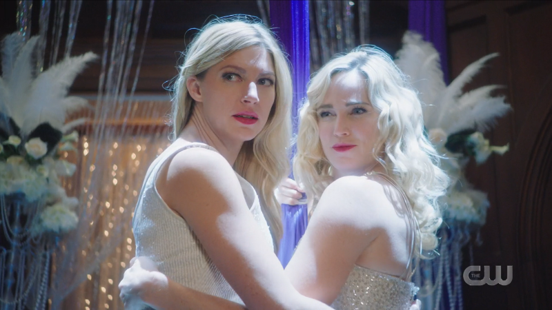 Sara and Ava break from their kiss to look at the crowd