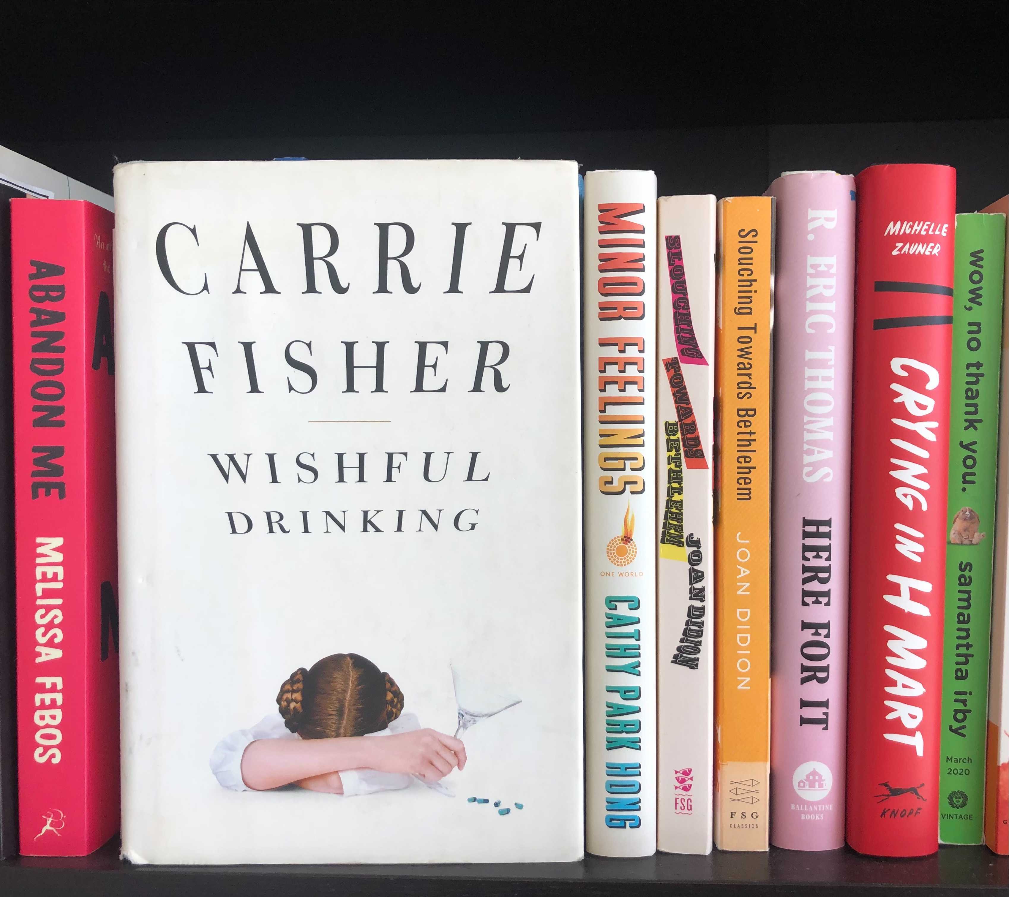 a copy of carrie fisher's wishful drinking on a bookshelf