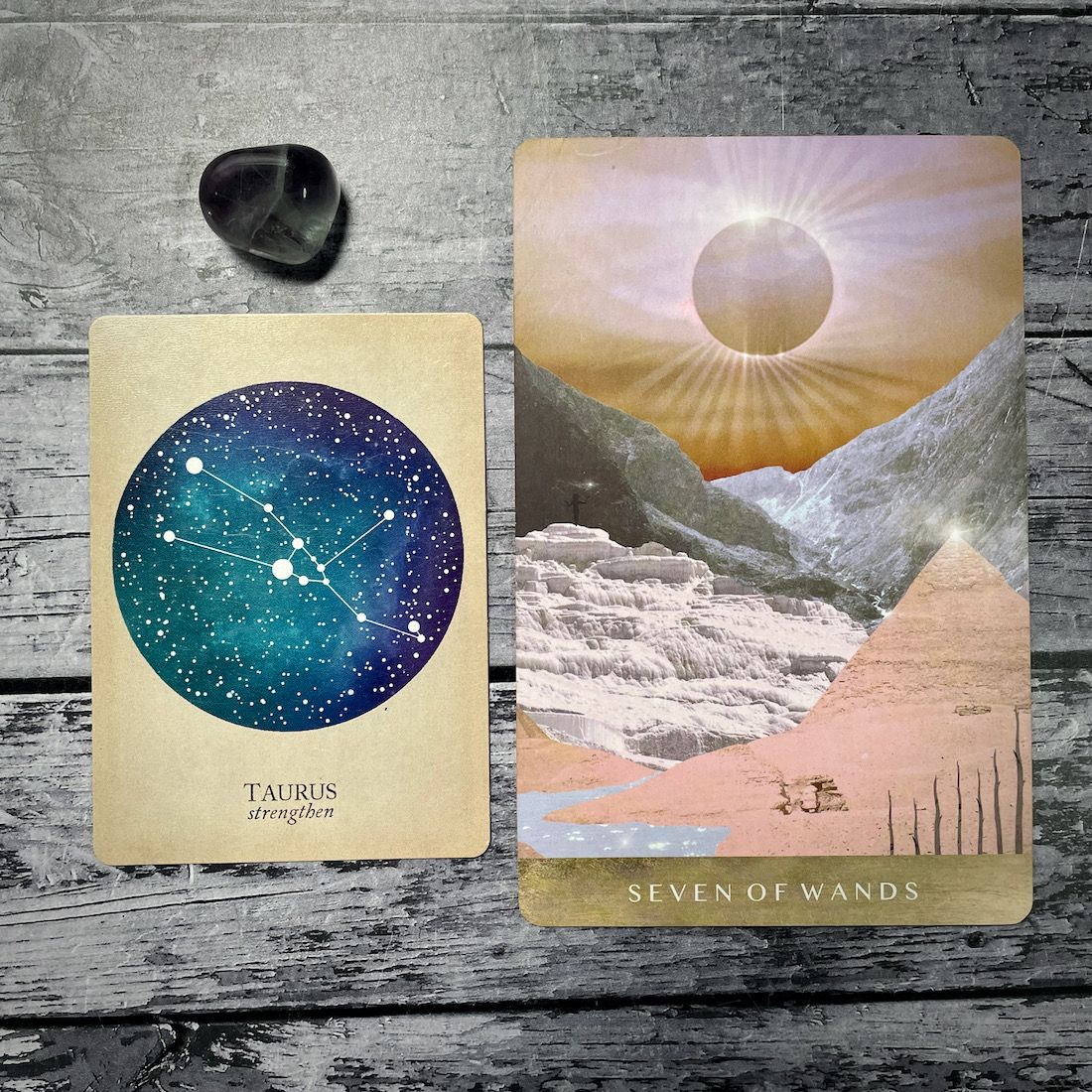 A card says taurus: strengthen with an aqua circle, next to a card that says seven of wands with an illustration of a sunrise