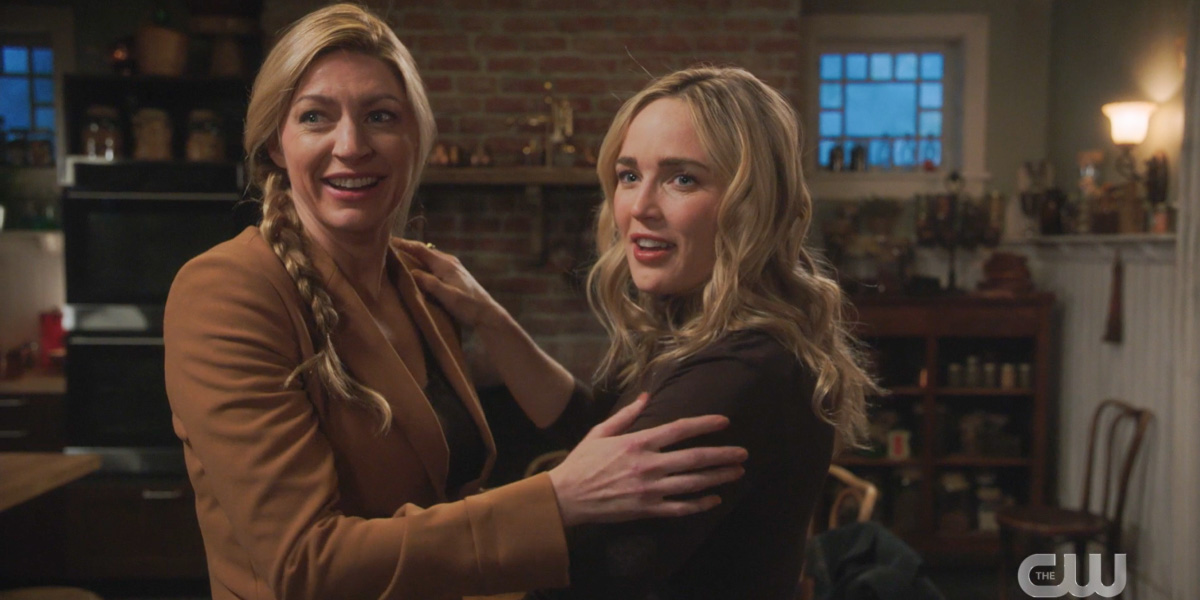 Ava and Sara hold each other and smile as they look offscreen toward their friends because they're gonna have an Avalance baby