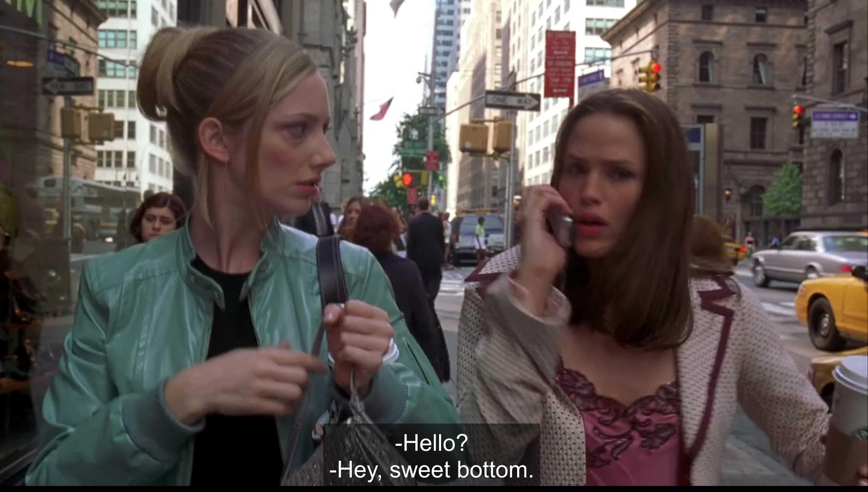 Lucy and Jenna are walking on a New York sidewalk, and Jenna is answering her phone to someone saying "Hey, sweet bottom" on the other end of the line.