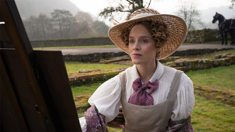 Ann Walker sits outside in front of an easel