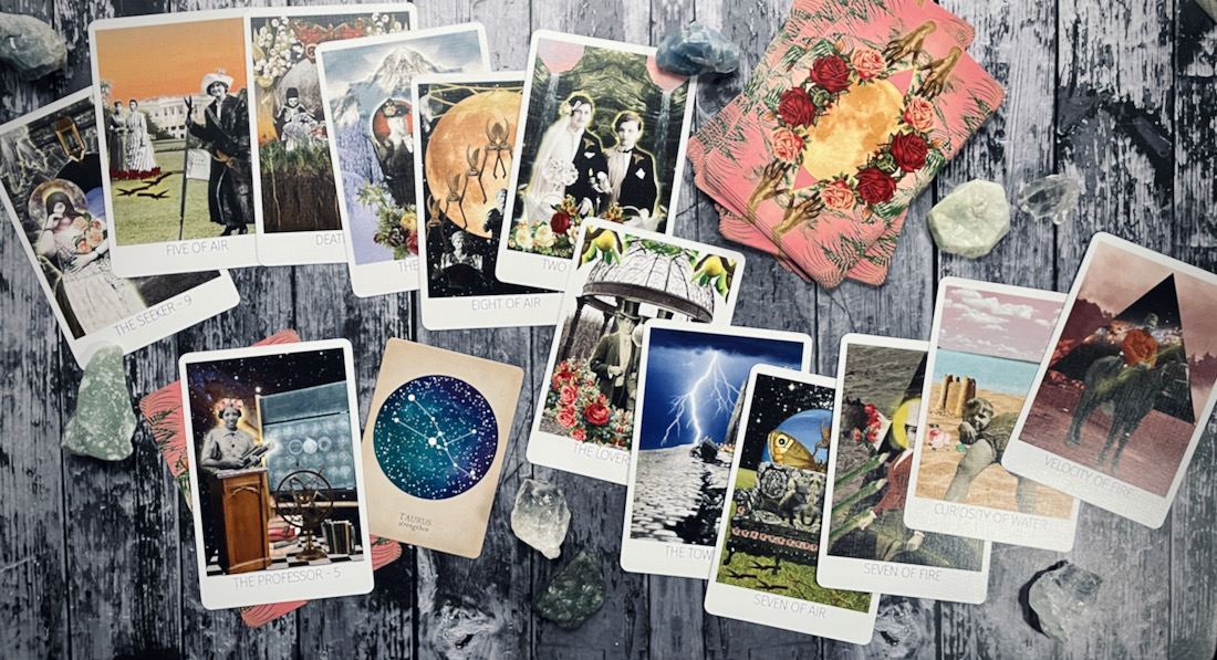 cards from the rosebud tarot and the compendium of constellations are displayed across a grey wood table