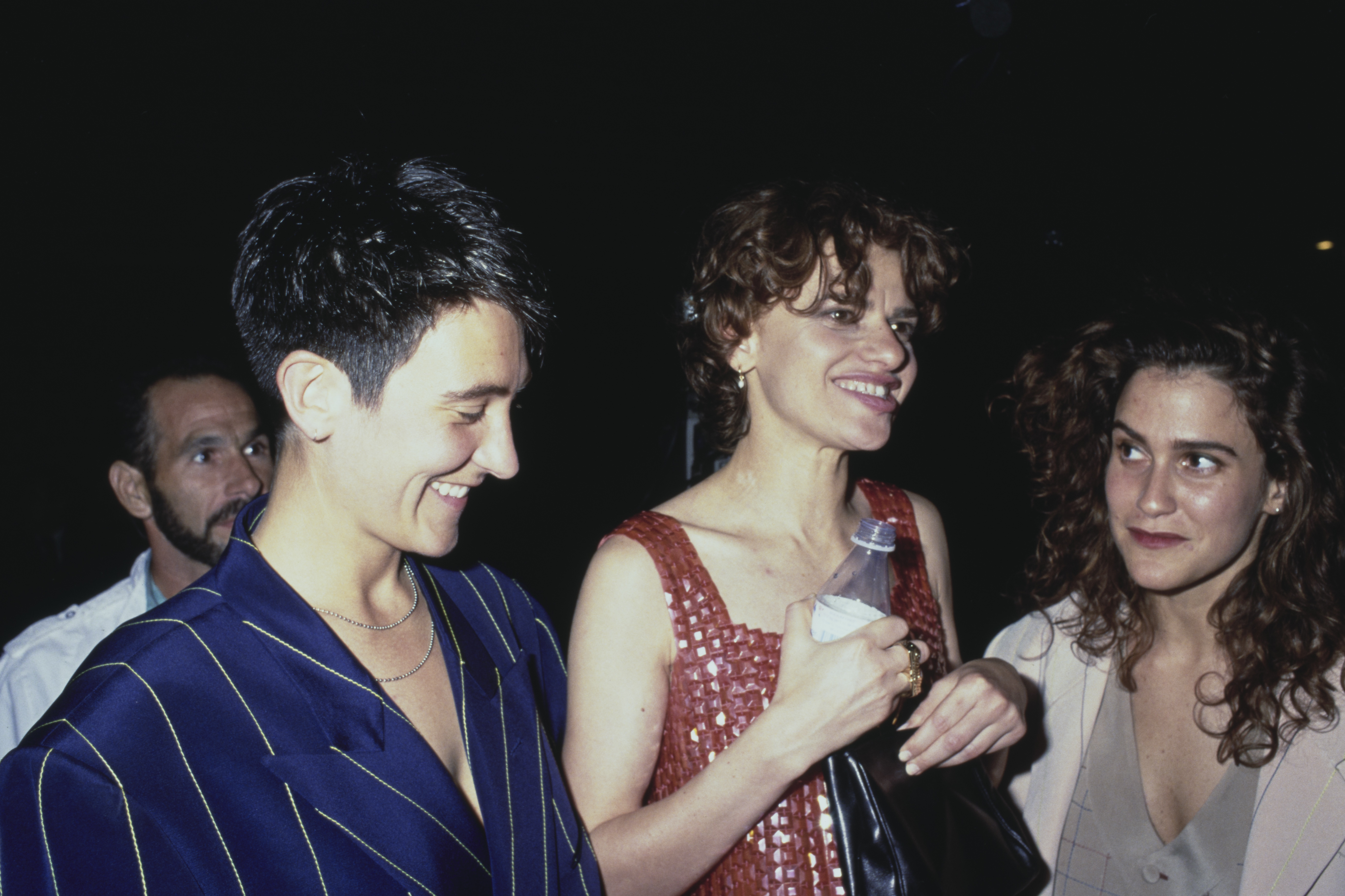 Canadian singer-songwriter kd lang, wearing a pinstripe blue jacket, and American actress and comedian Sandra Bernhard, wearing a red minidress, and American singer-songwriter and guitarist Wendy Melvoin attend the Los Angeles premiere of 'Truth or Dare' held at the Pacific Cinerama Dome in Los Angeles, California, 6th May 1991. (Photo by Vinnie Zuffante/Michael Ochs Archives/Getty Images)