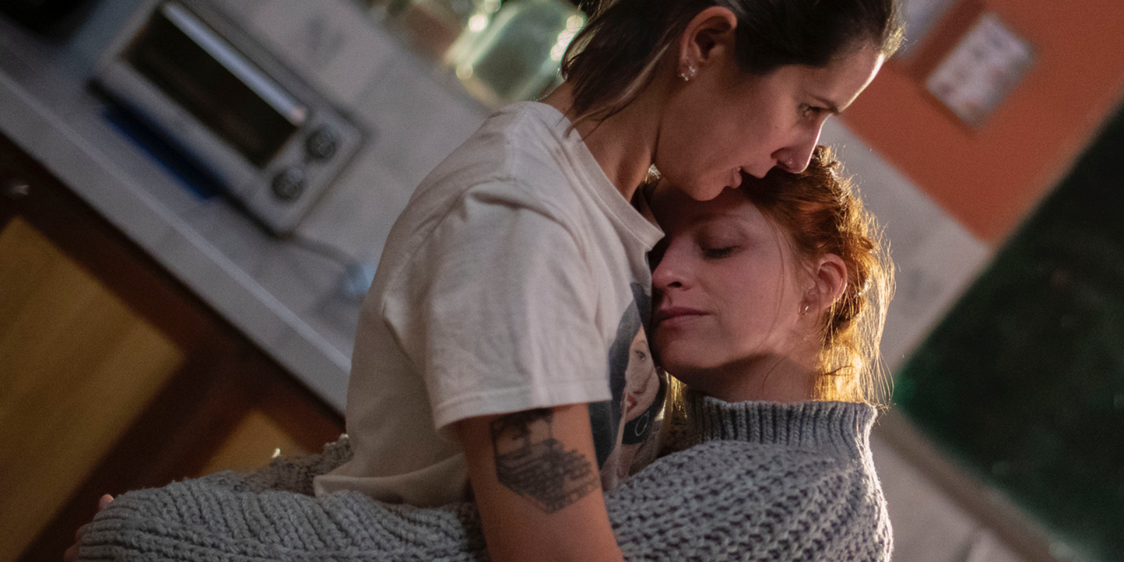 A couple comforting each other in the kitchen