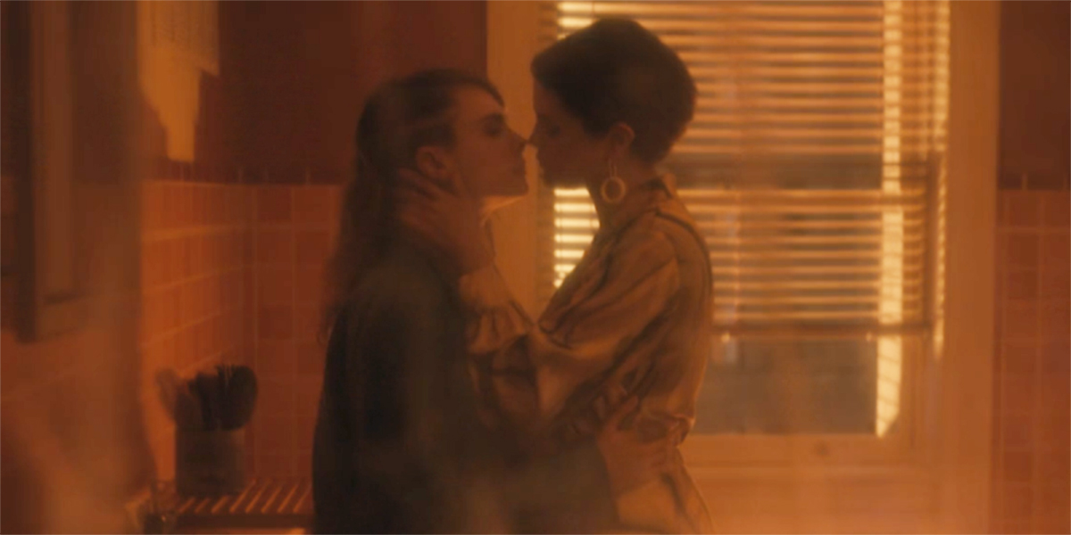 Mabel and Alice stand leaning against each other against the bathroom sink, their mouths kissing distance apart, and we're viewing them through the hazy film of the shower curtain