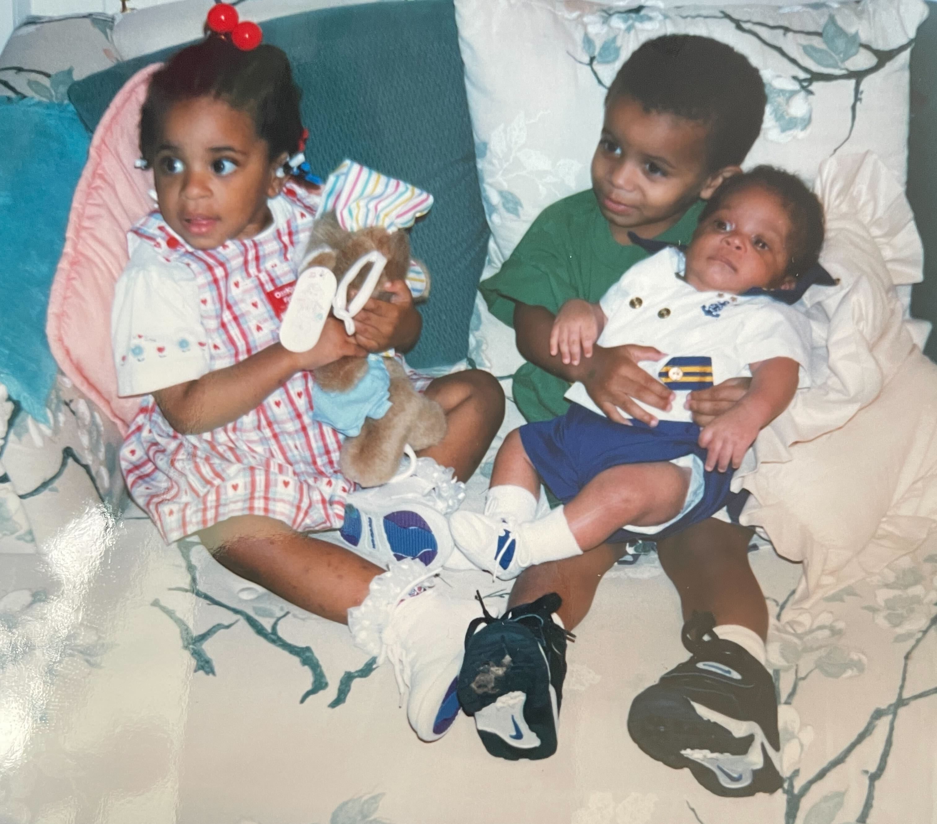 Dani, Dave, and Dakota sit on a couch, Dave is holding Dakota