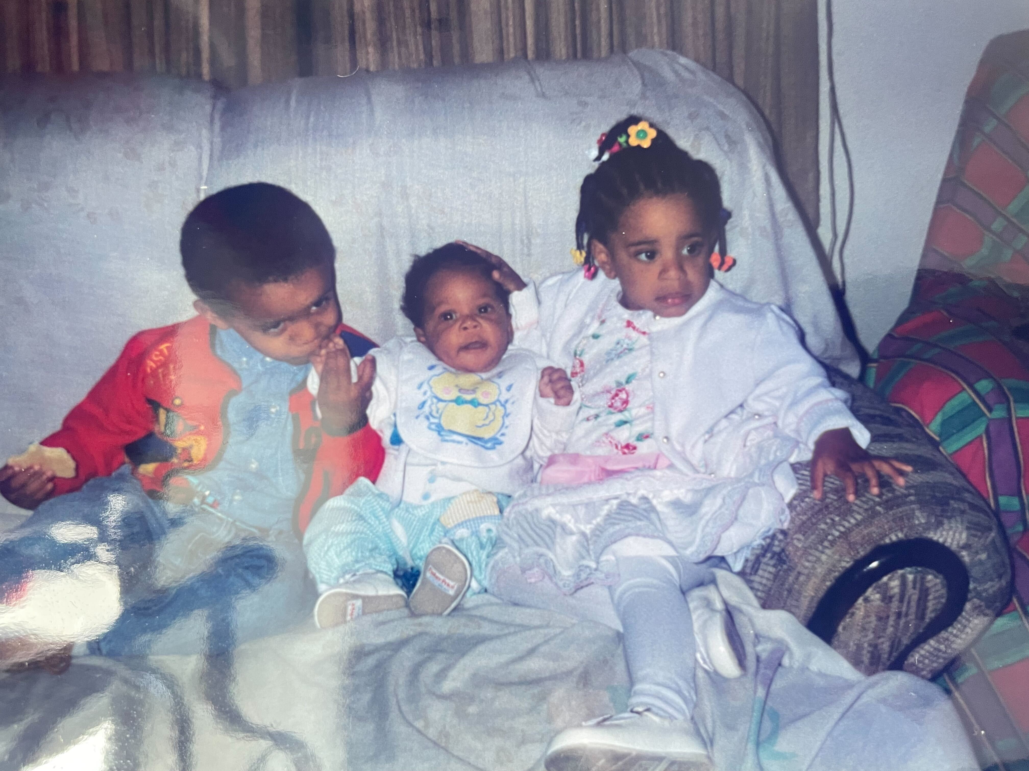 Dave, Dakota, and Dani, sitting on a couch, Dave is kissing Dakota's hand