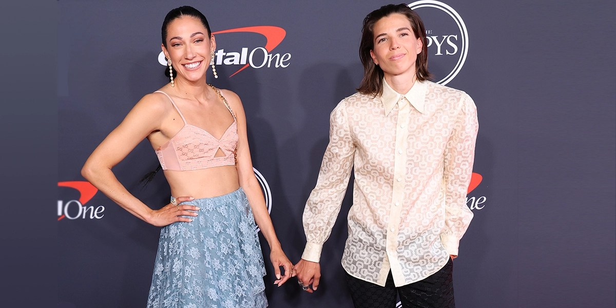 christen press and tobin heath holding pinkies at an event