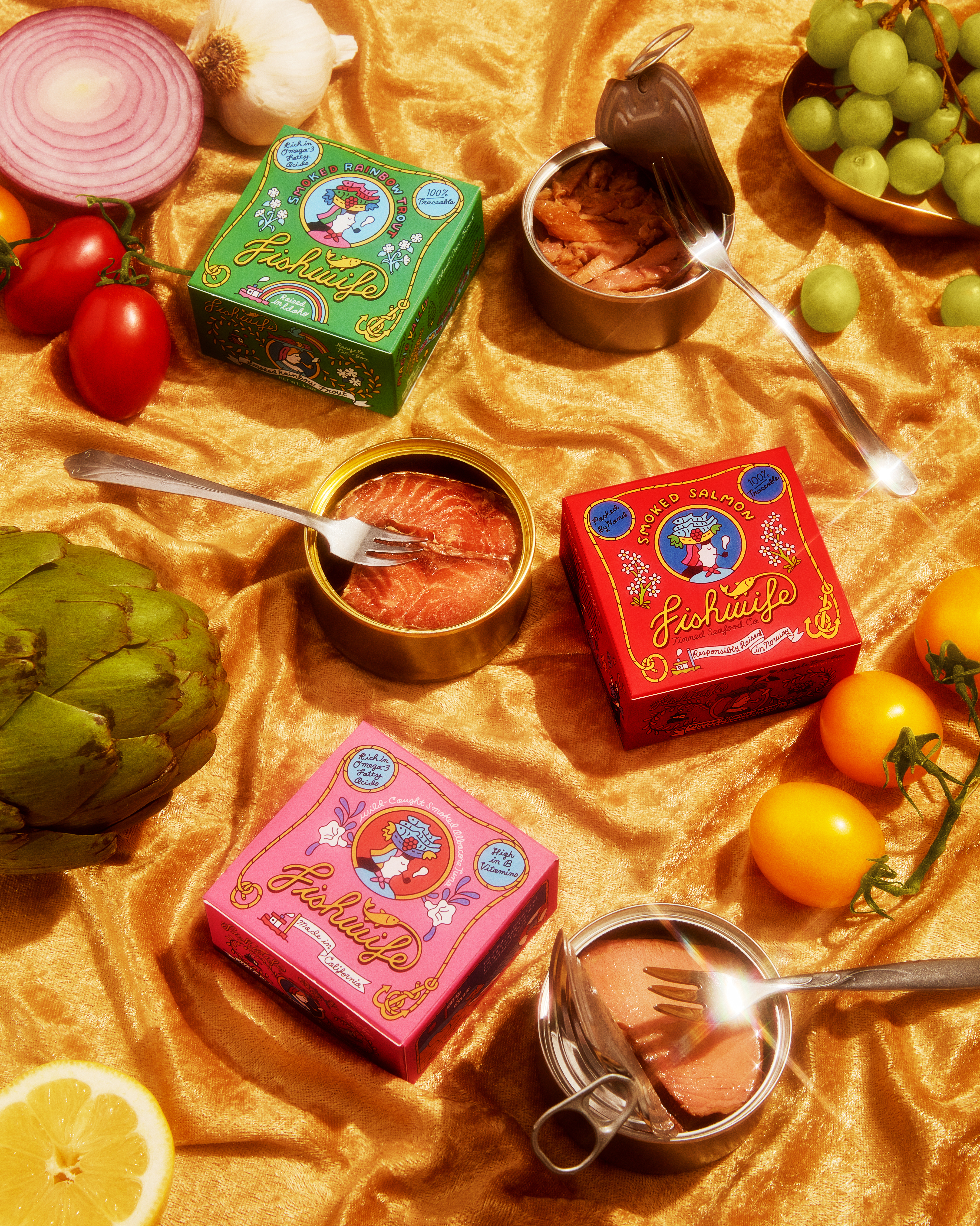 a gorgeous display of various fishwife canned fish offerings, tins open, upon a golden velvet background, dotted with fruits and vegetables