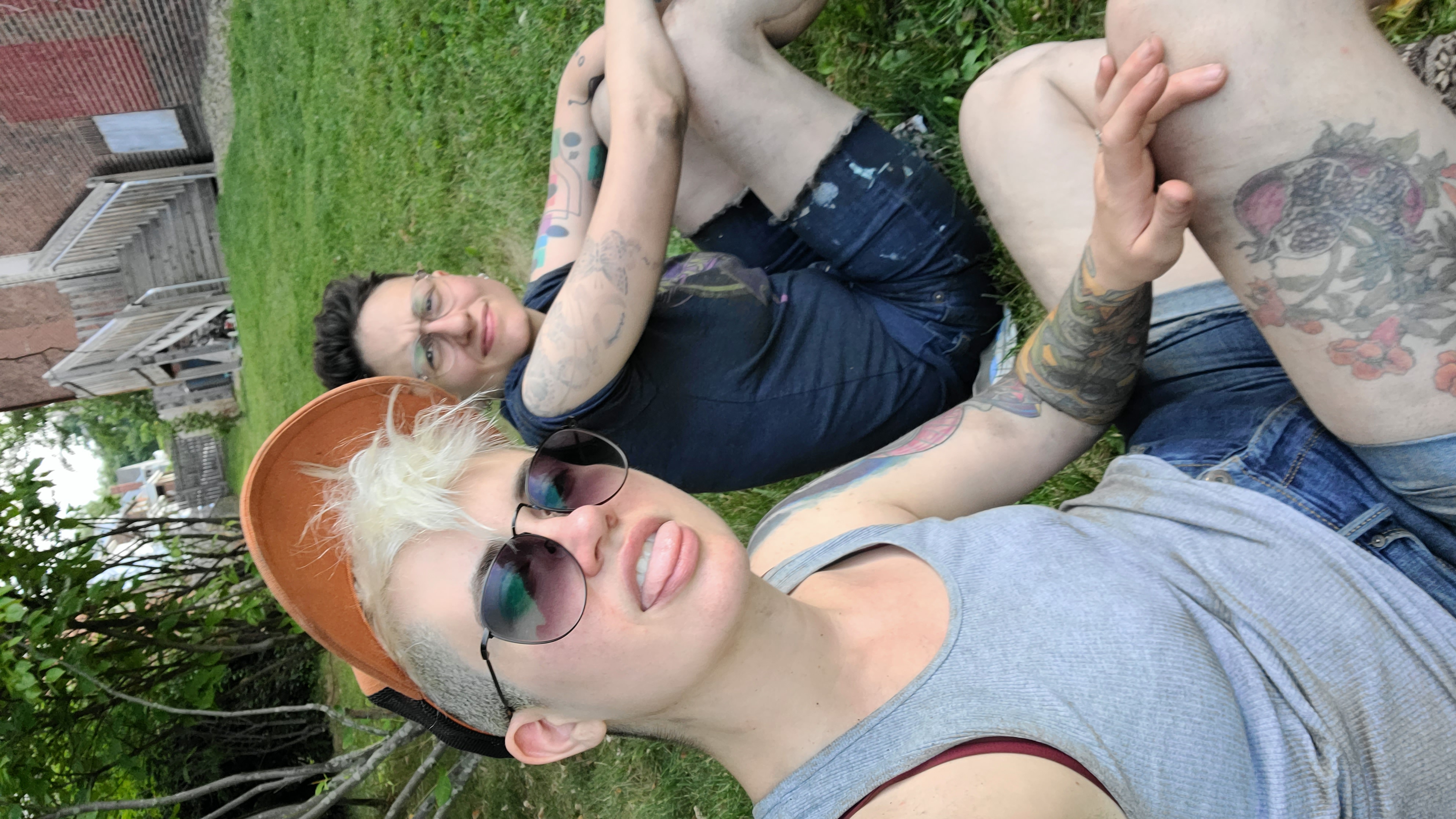 sadie and nico sitting in the grass, looking super gross and dusty from doing home reno
