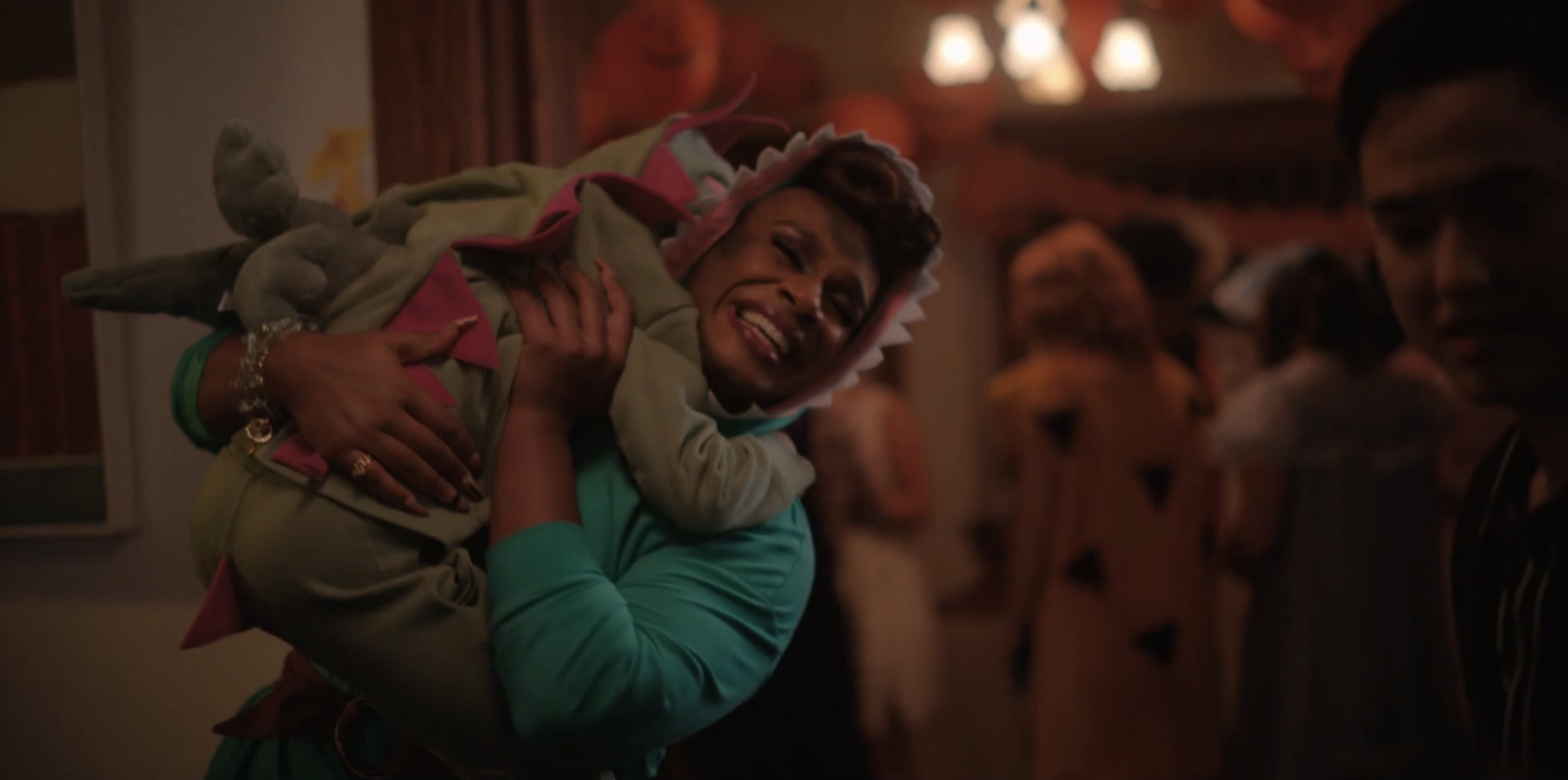 Rhys in a dinosaur suit holding their kid