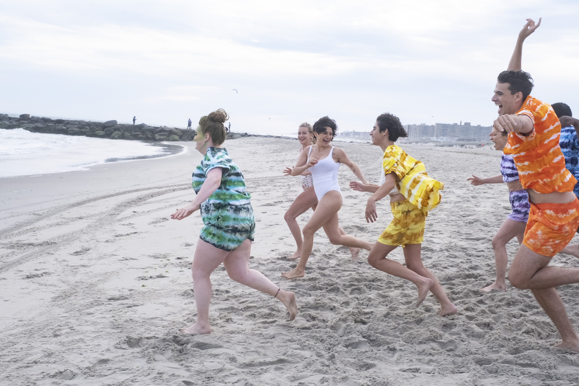 Everybody running on the beach in bright colored outfits