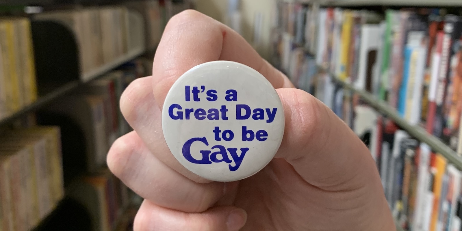 a white hand holds a button that reads 