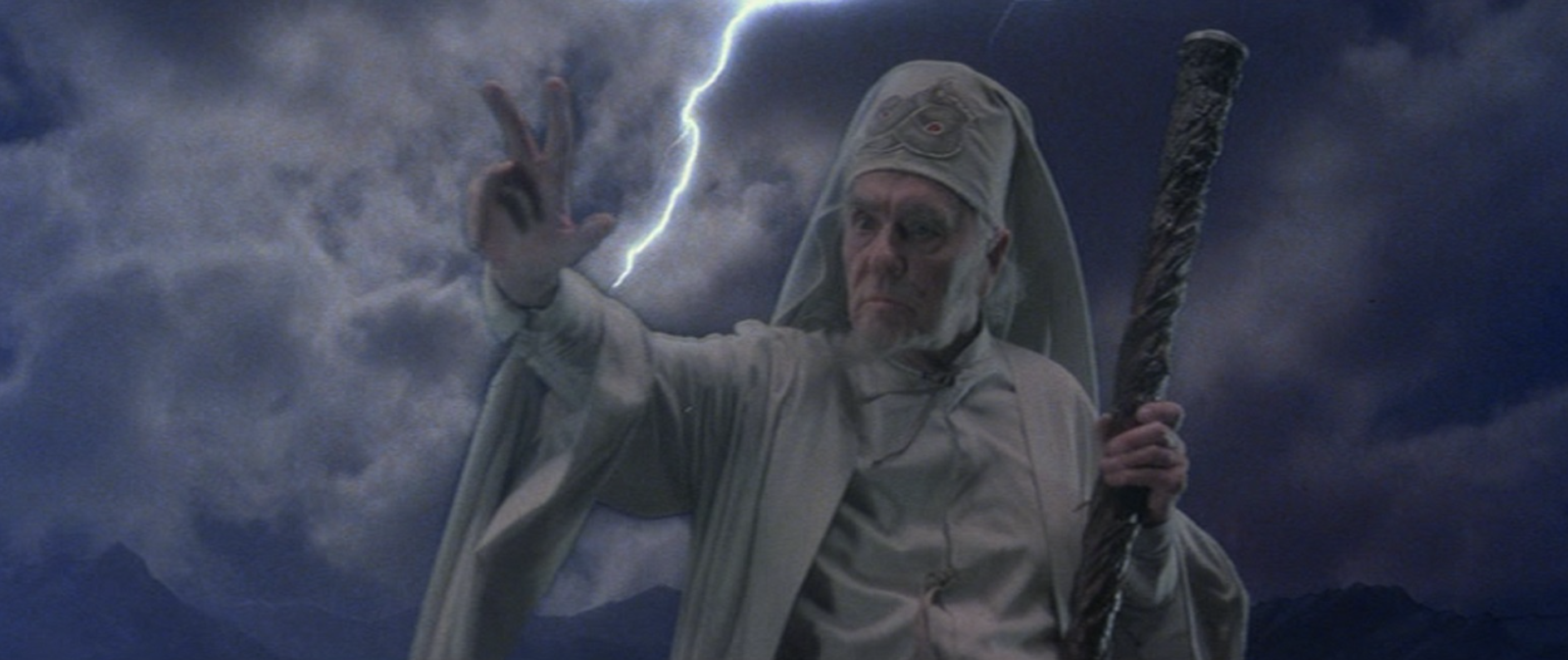 an old white guy wizard in a white outfit gestures while lightning strikes behind him