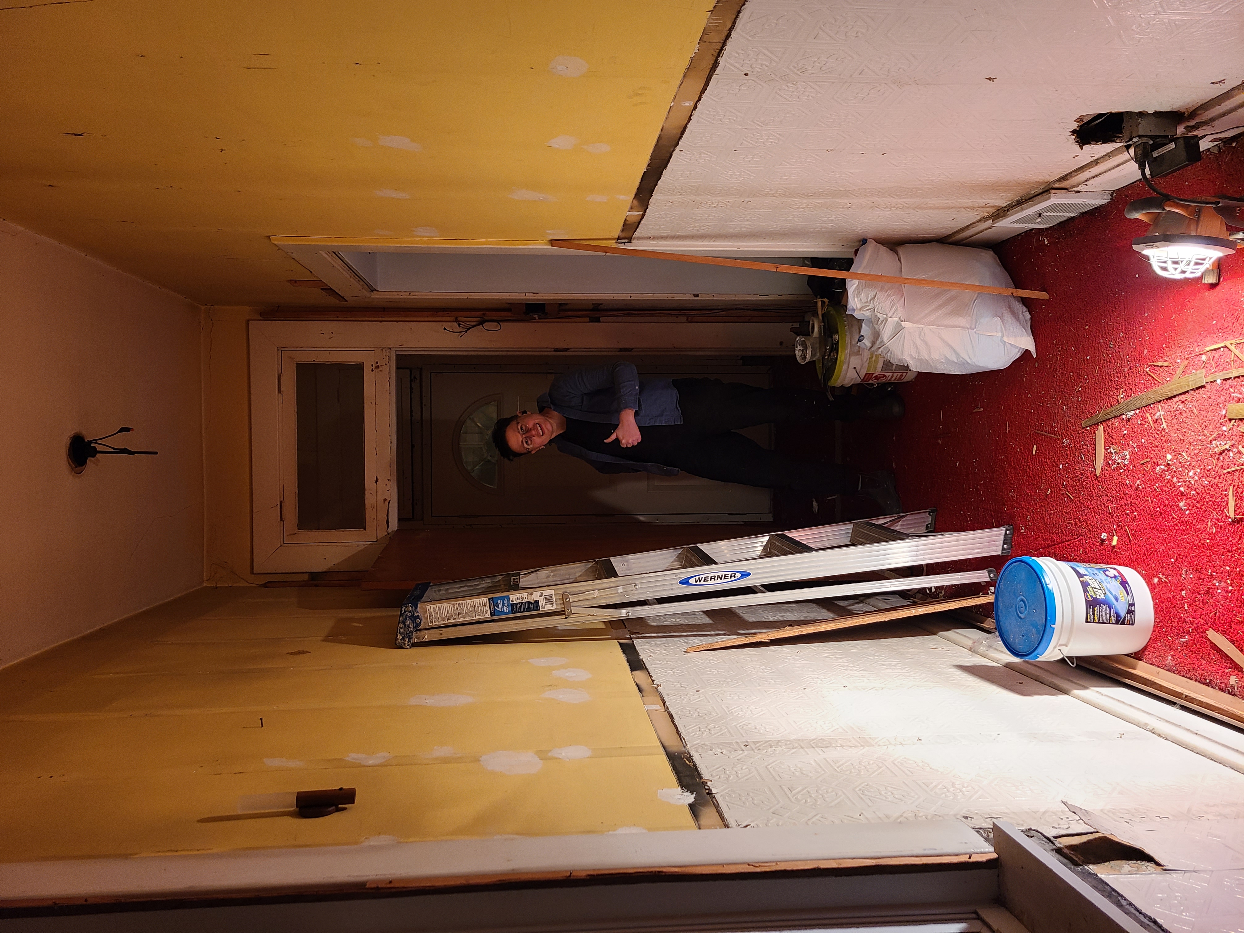 in a half-renovated, darkened hallway, sadie gives a thumbs up at the end